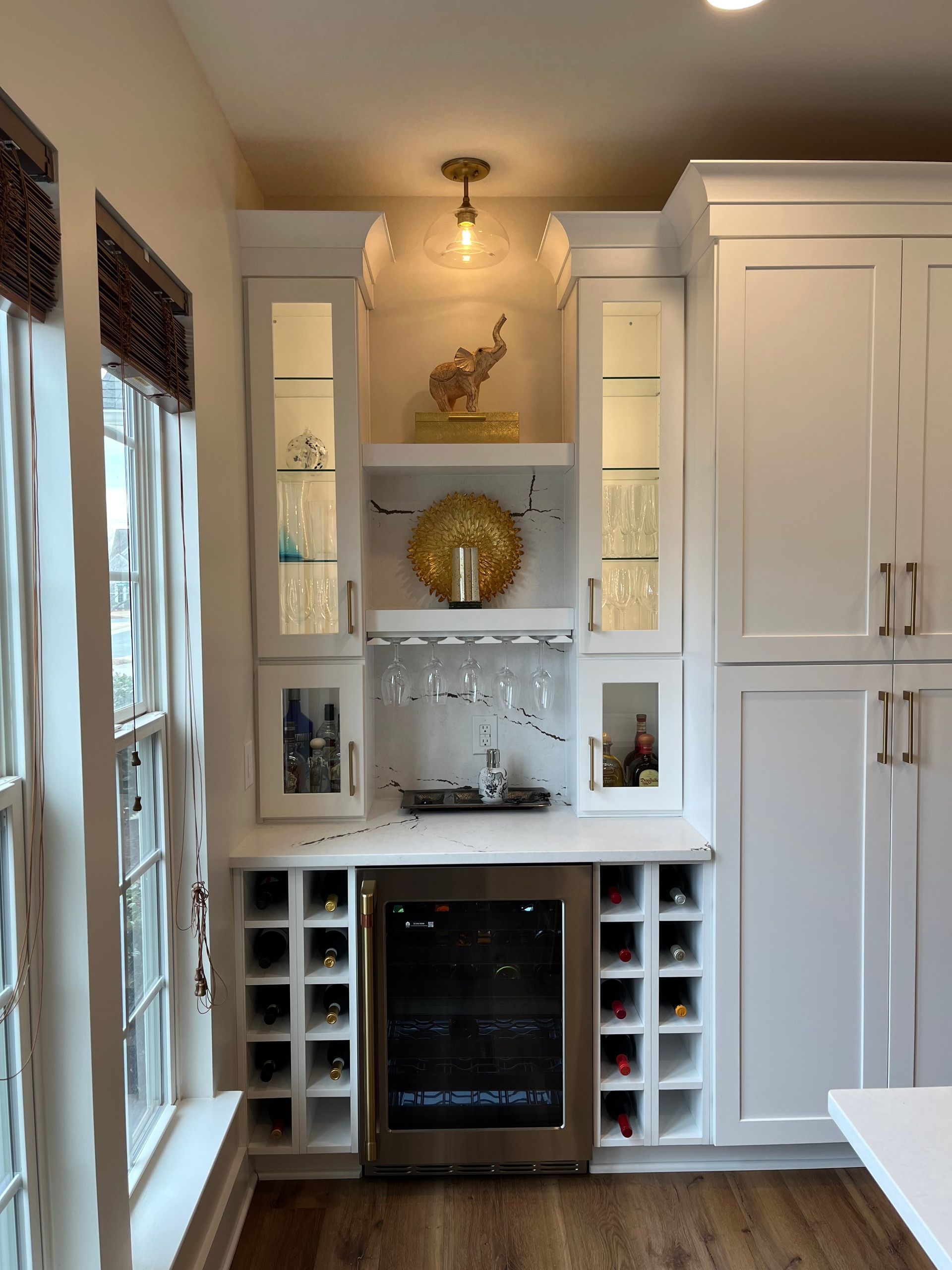 A kitchen with white cabinets and a wine cooler
