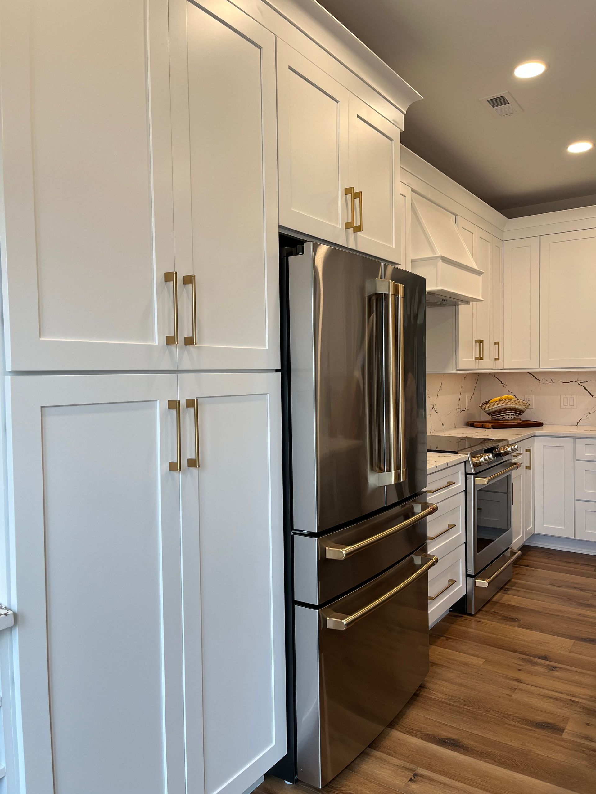 A kitchen with white cabinets and stainless steel appliances