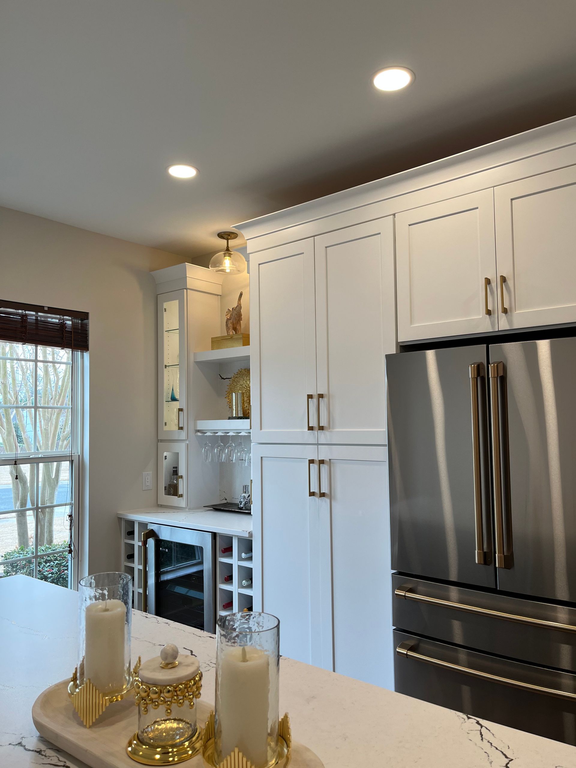 A kitchen with white cabinets and a stainless steel refrigerator
