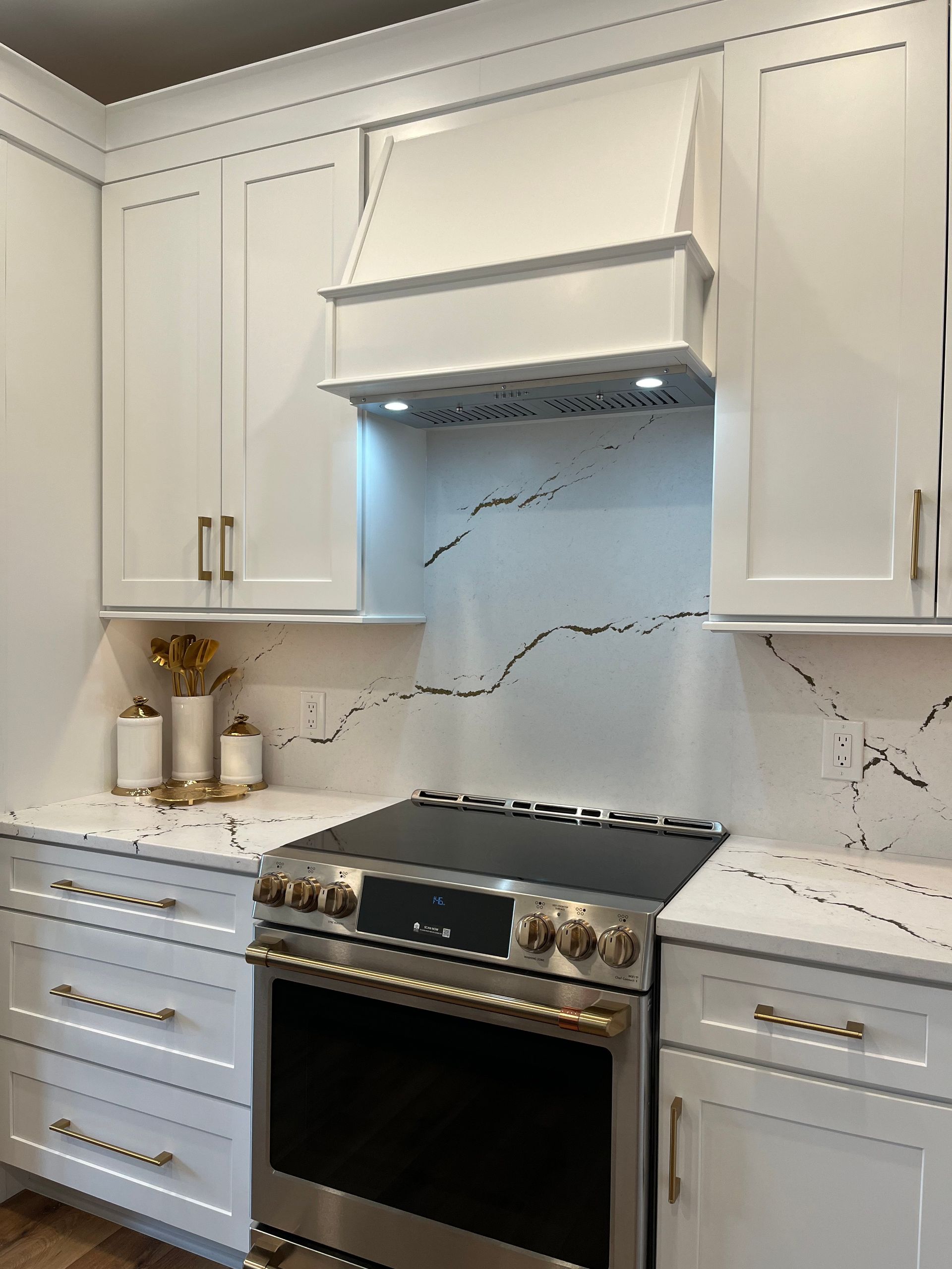 A kitchen with white cabinets and a stove top oven.