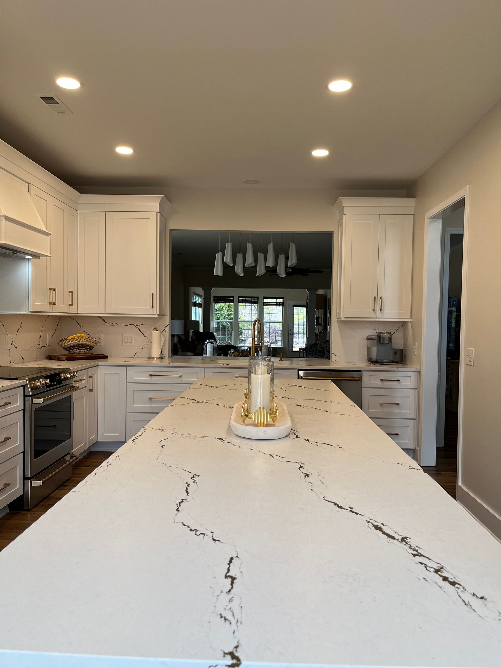 A kitchen with white cabinets and a large island with a candle on it.