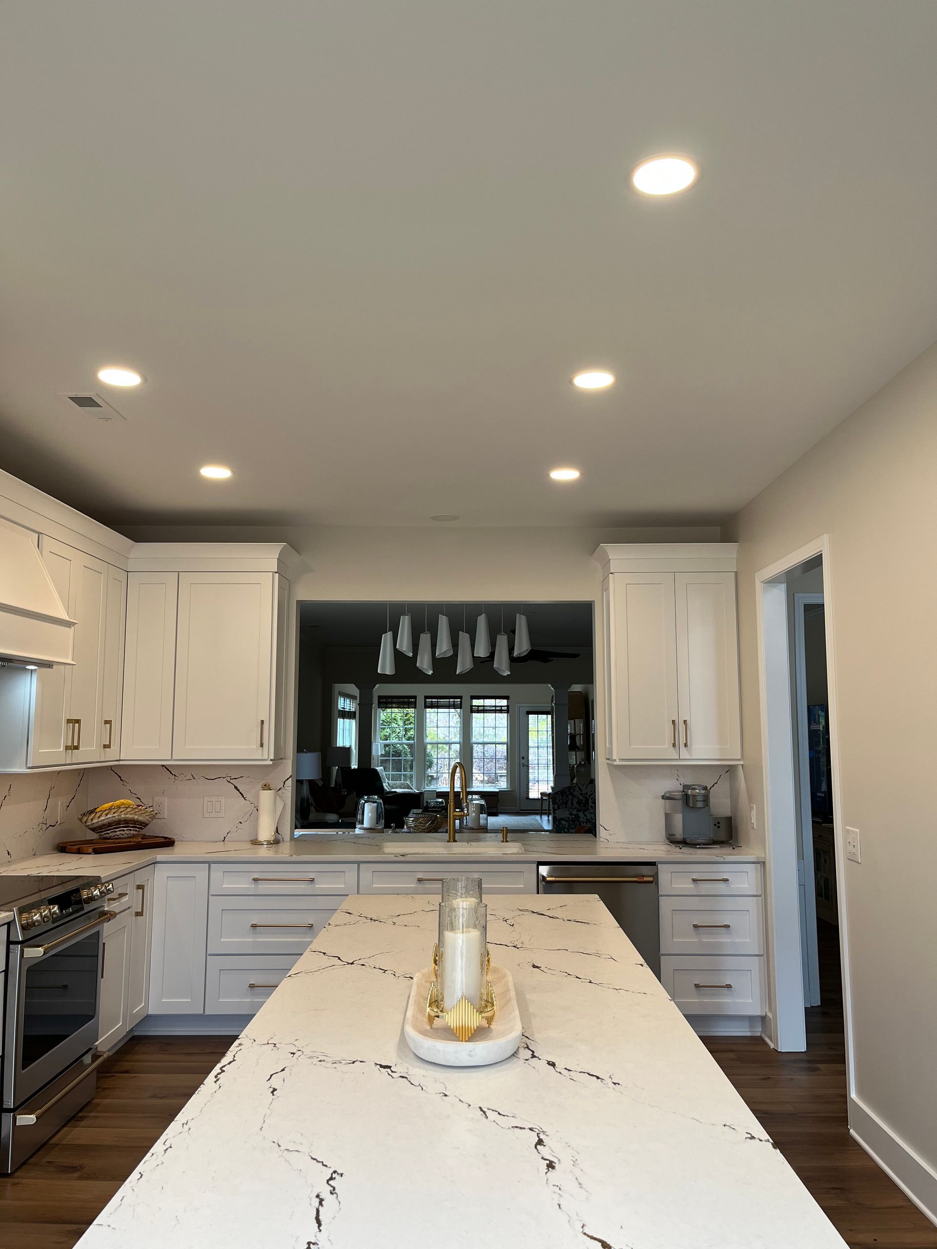 A kitchen with white cabinets and a large island with a candle on it.