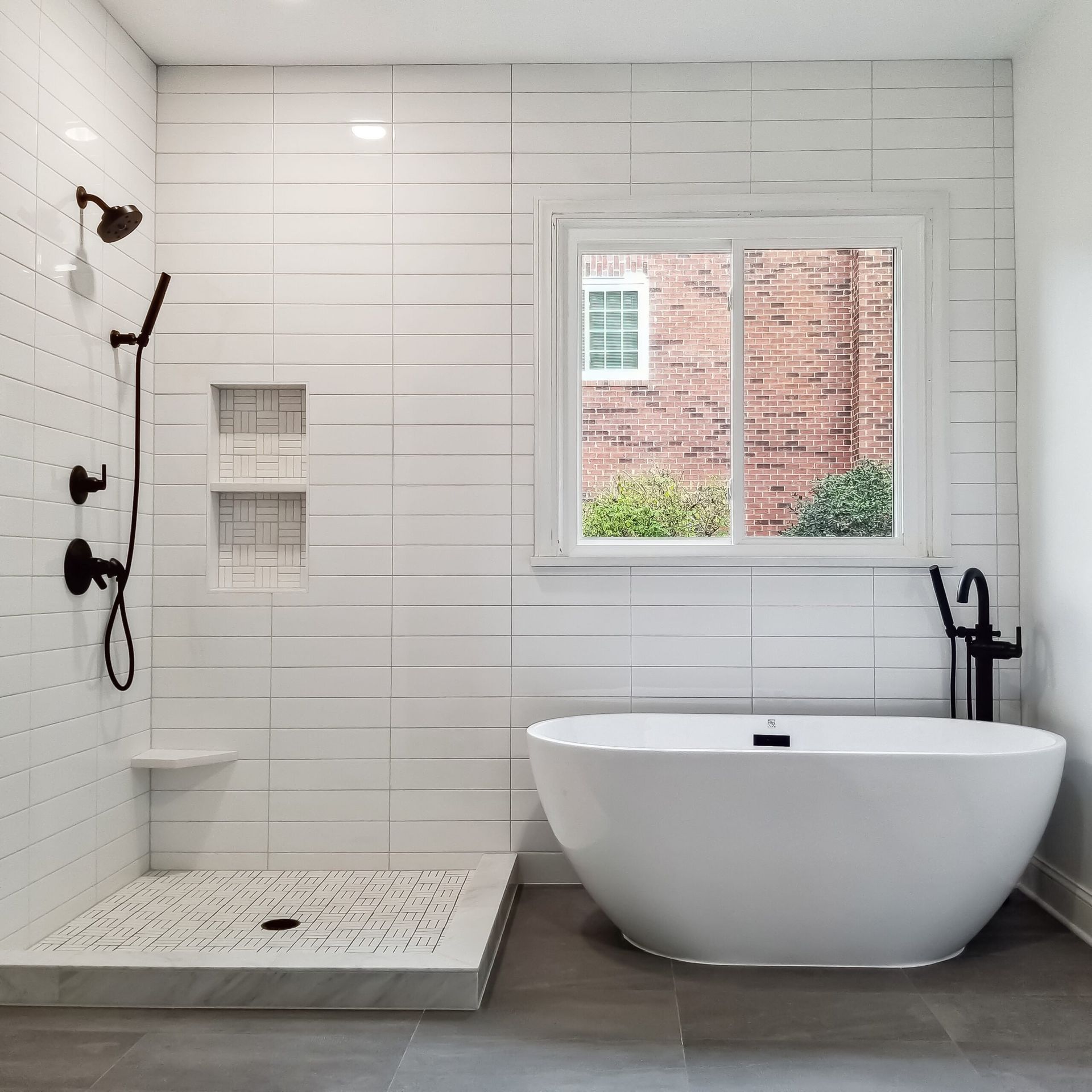 A bathroom with white tiles and a tub and shower