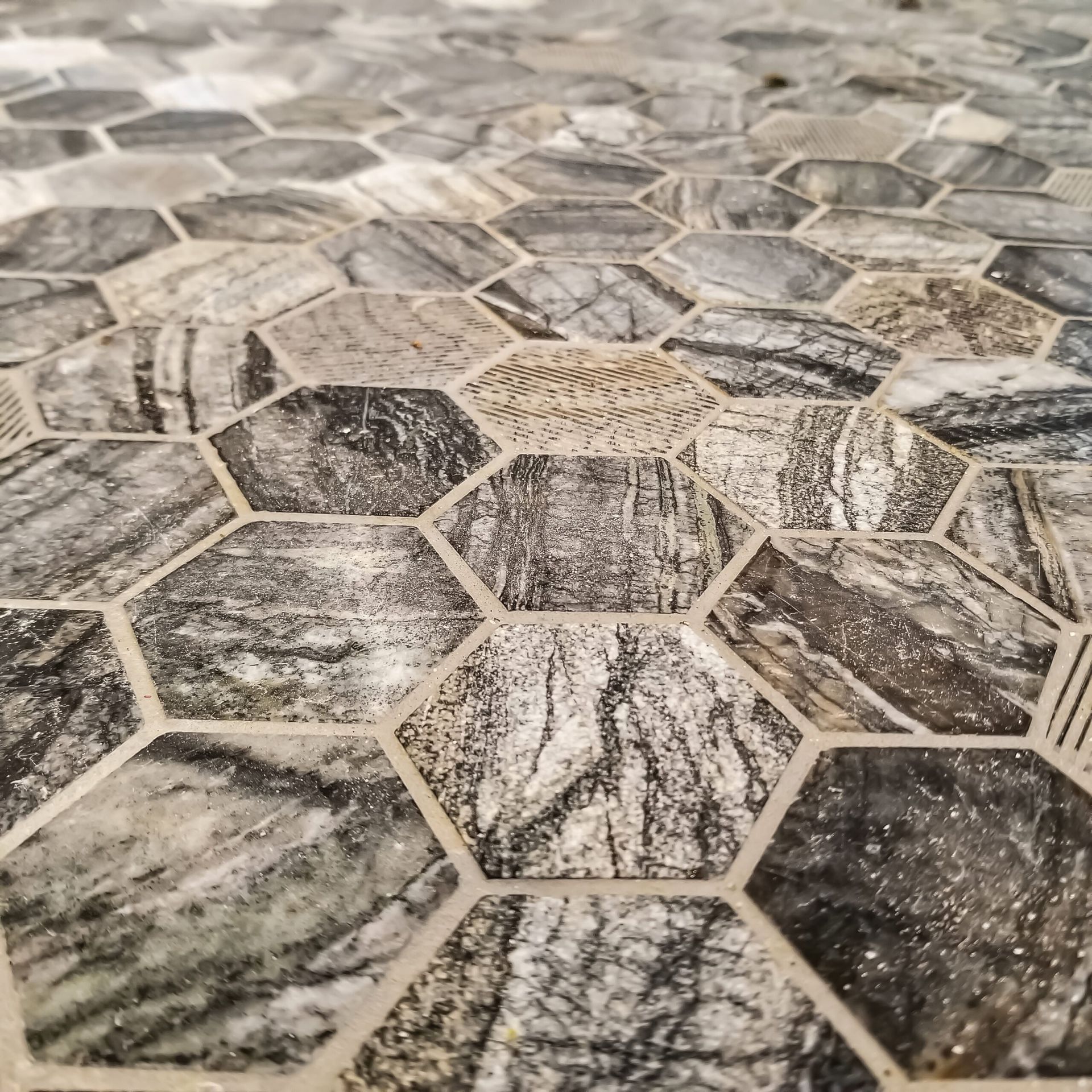 A close up of a tile floor with a hexagon pattern