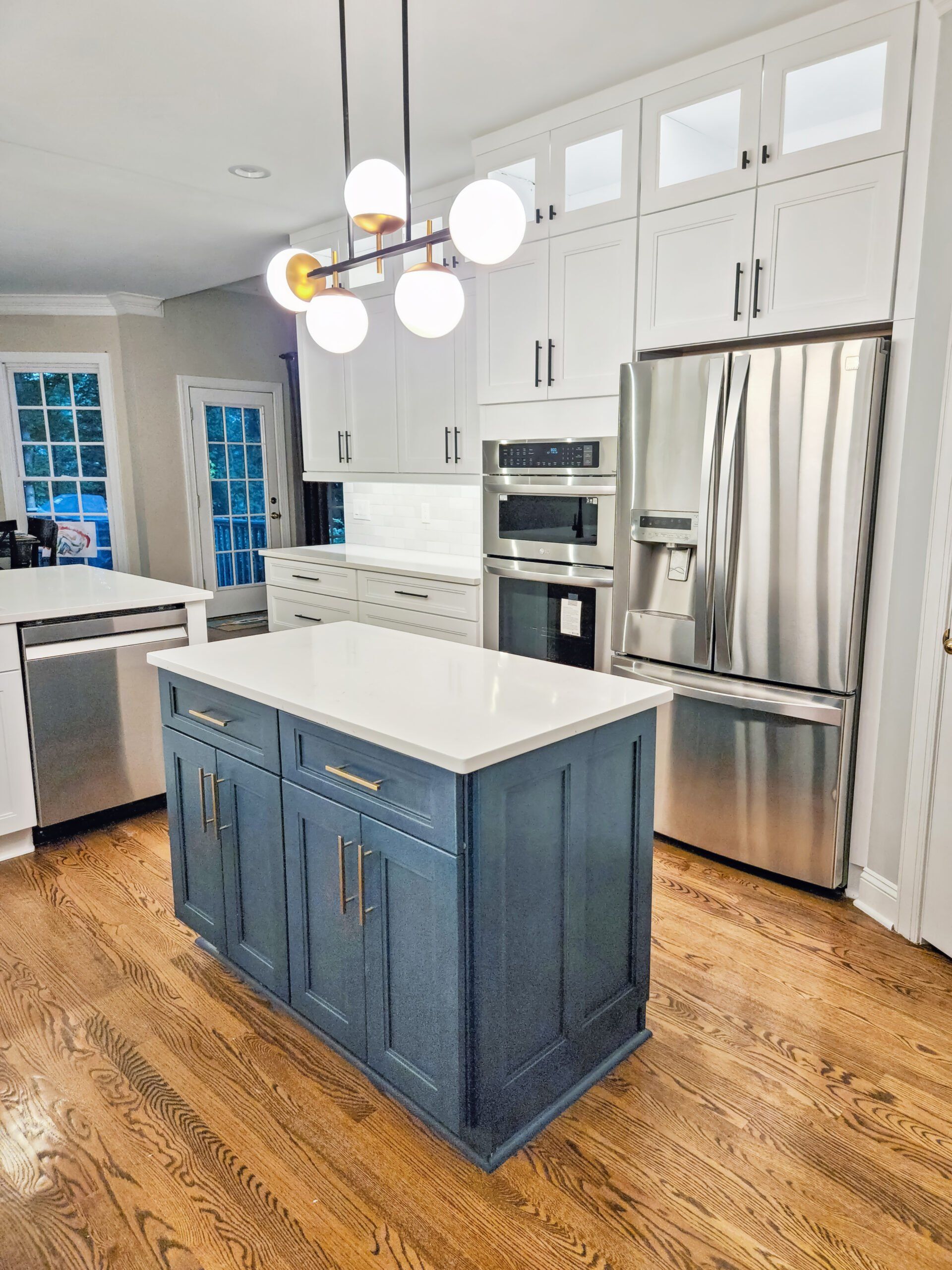 A kitchen with stainless steel appliances and a large island in the middle.