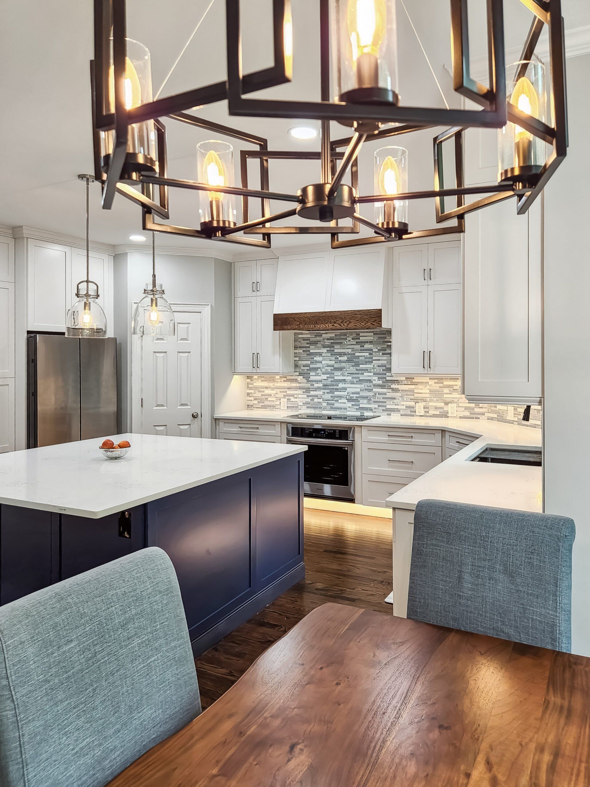 A kitchen with a table and chairs and a chandelier hanging from the ceiling.