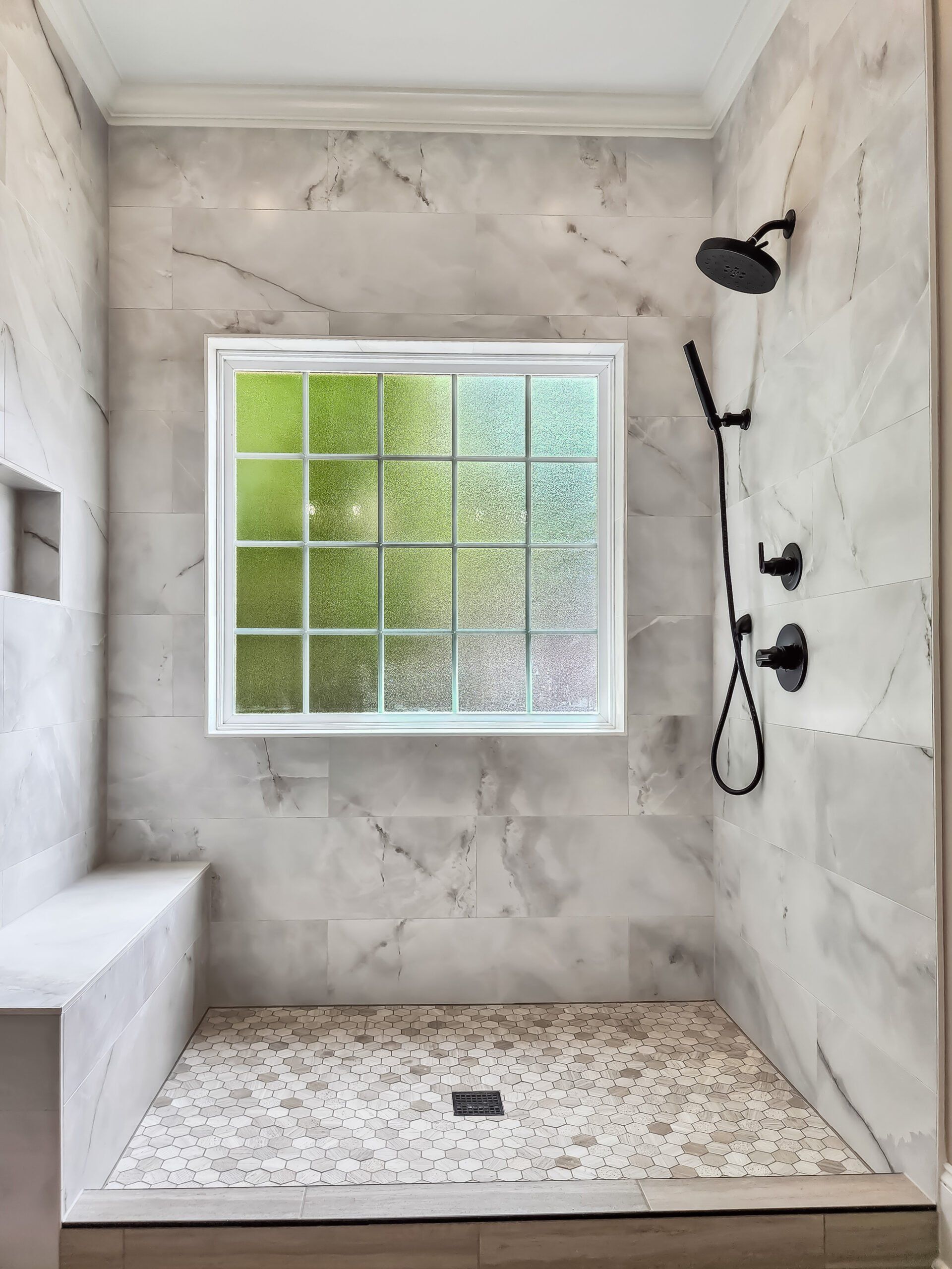 A shower with a window and a shower head