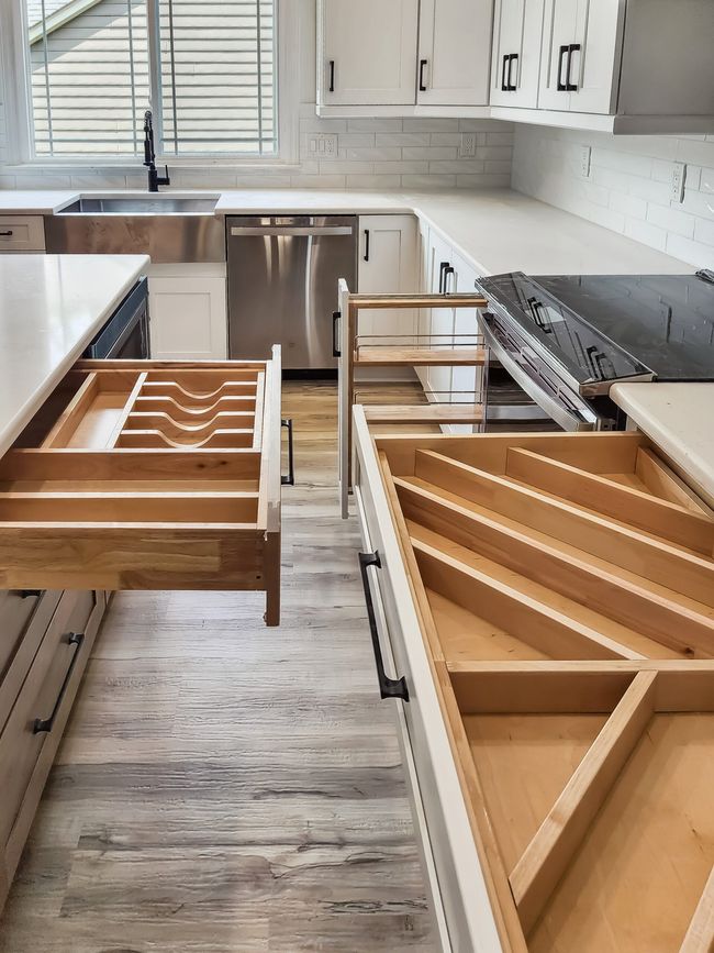 A kitchen with wooden drawers and a stove top oven
