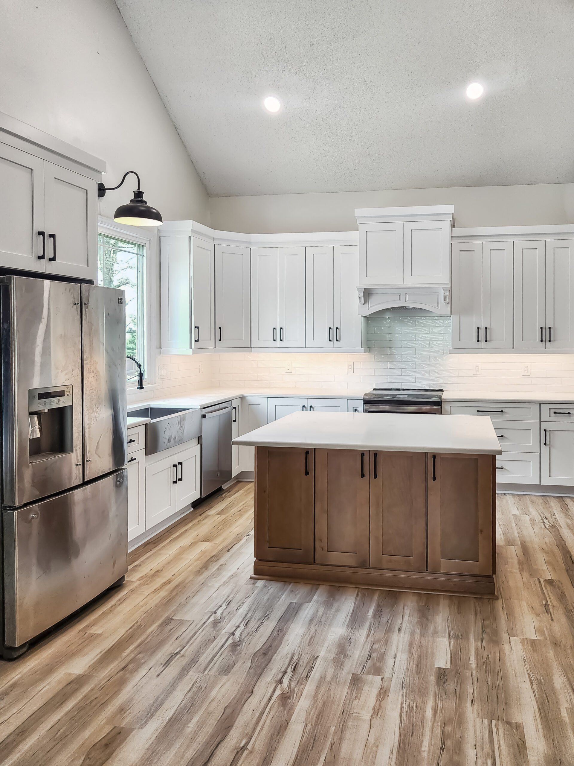A kitchen with stainless steel appliances , wooden cabinets , and a large island.