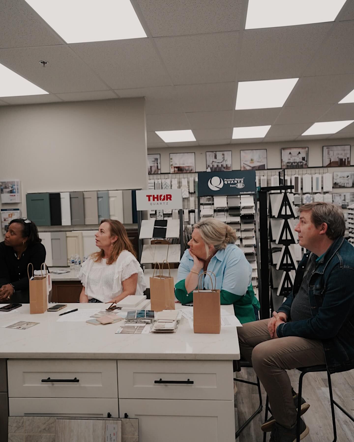 A group of people are sitting at a table in a store.