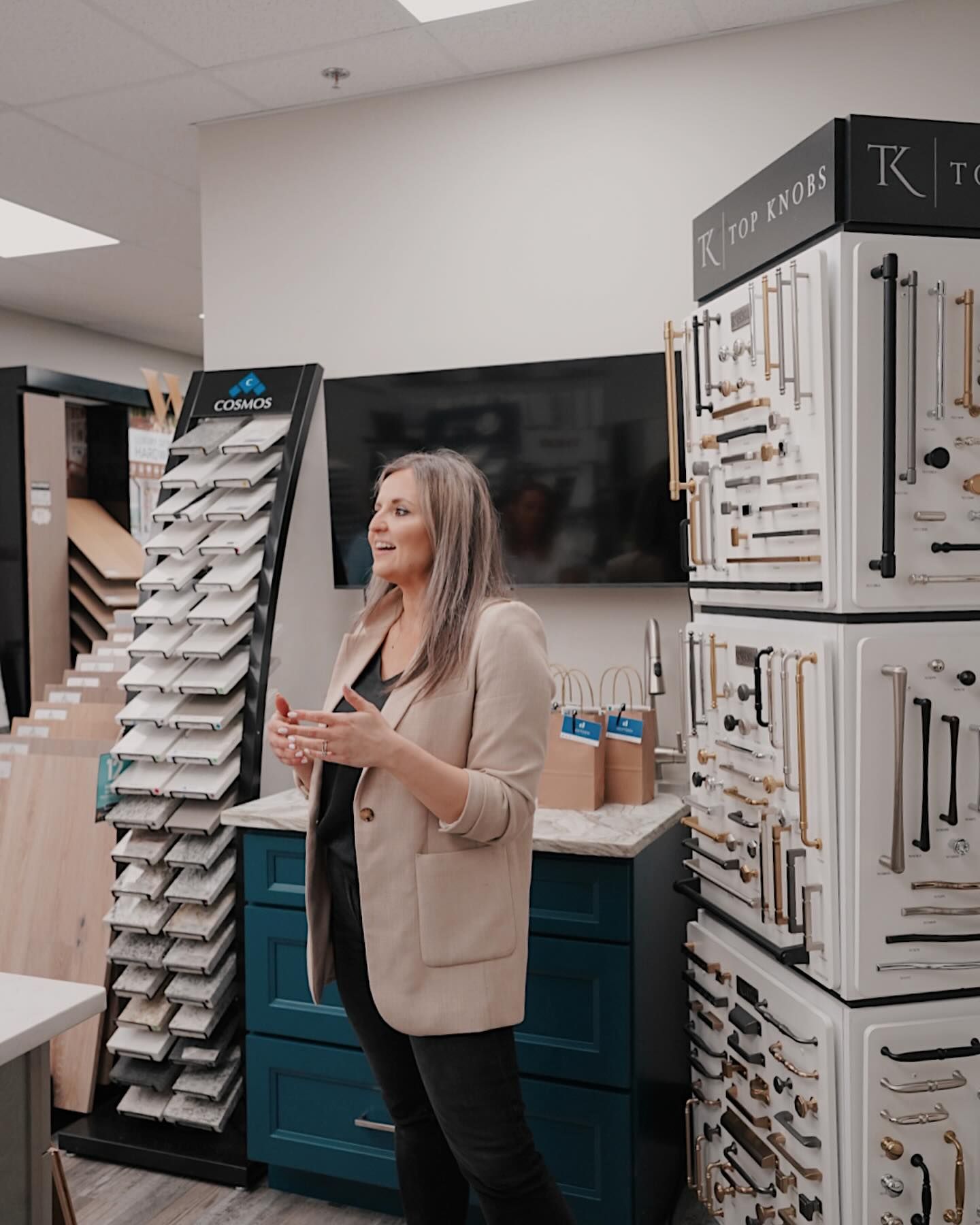A woman is standing in a room with a lot of cabinet handles.