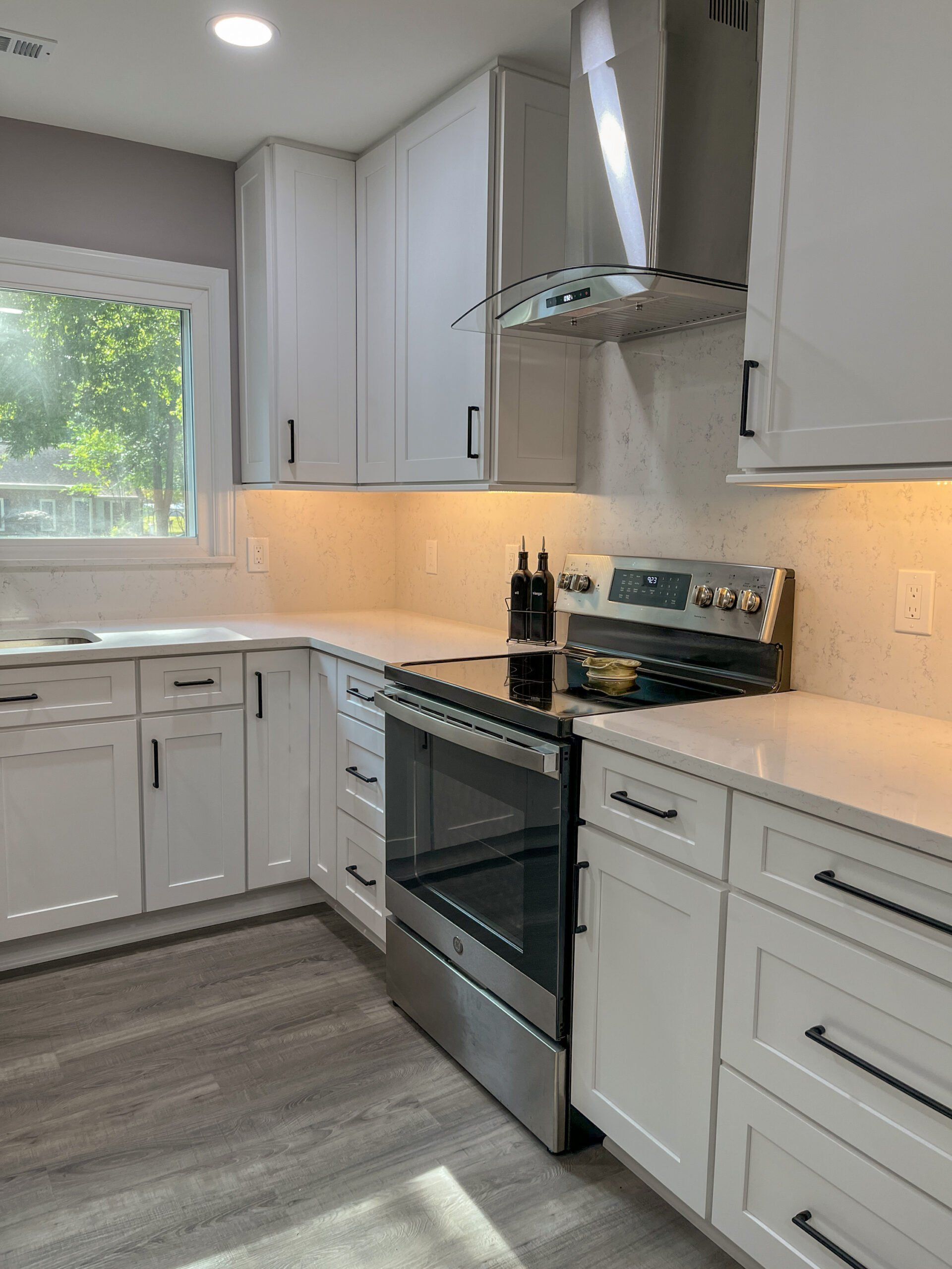 A kitchen with white cabinets and stainless steel appliances