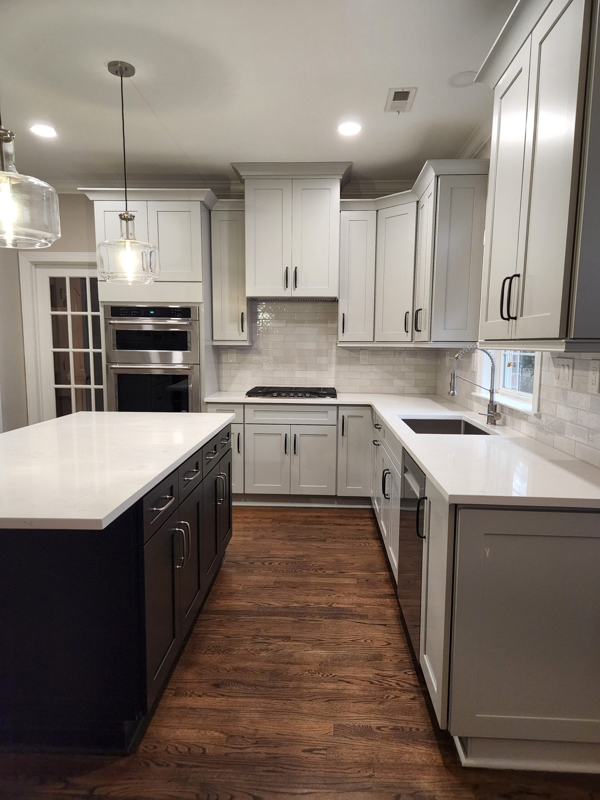 A kitchen with white cabinets and a large island.