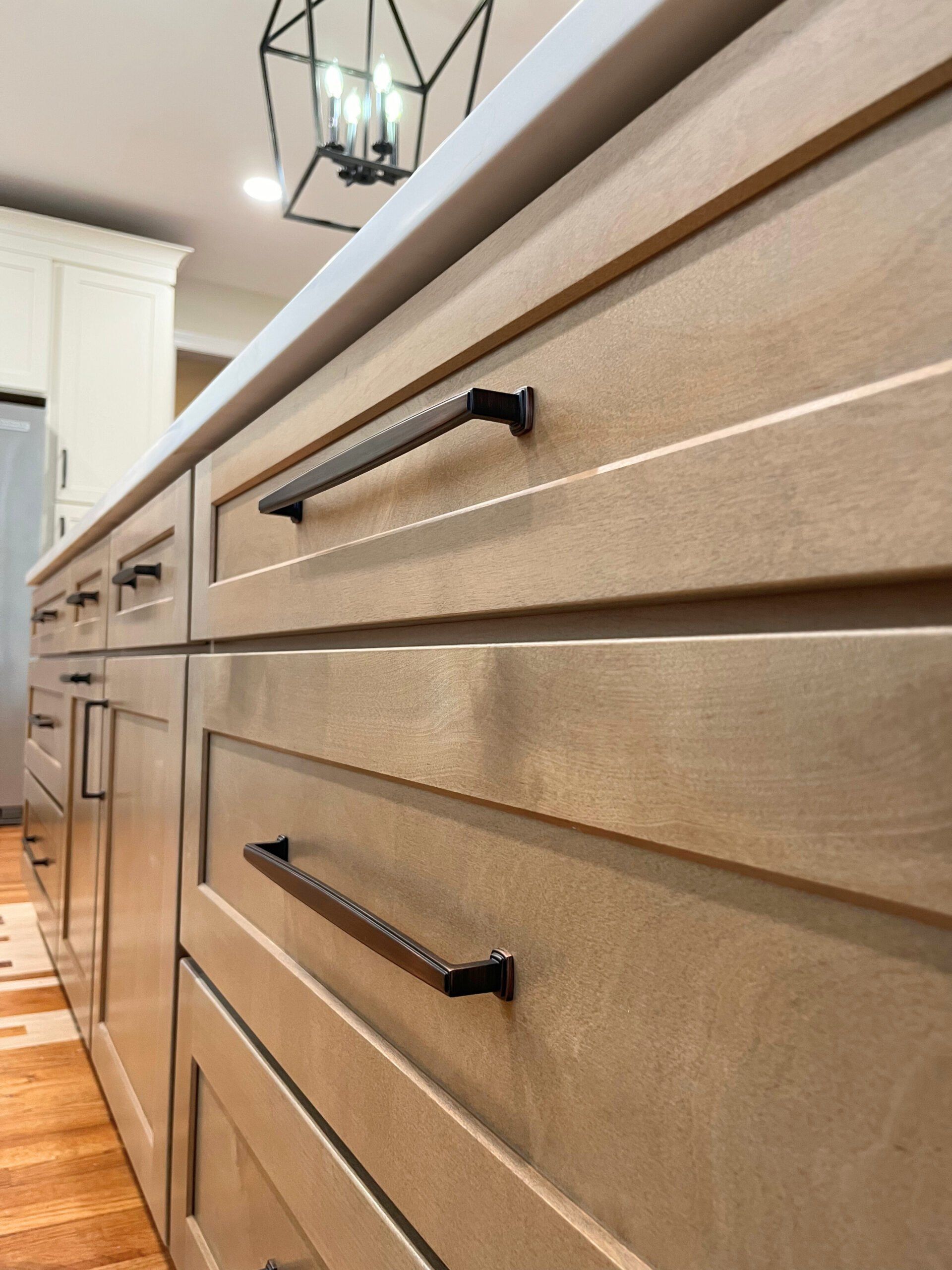 A kitchen with wooden cabinets and black handles