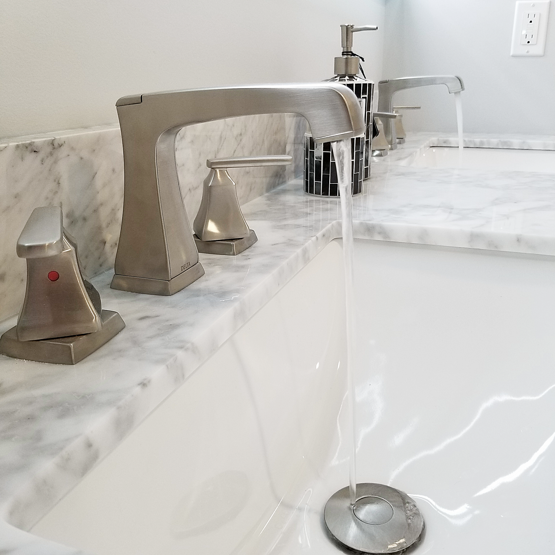 A bathroom sink with a soap dispenser on the counter