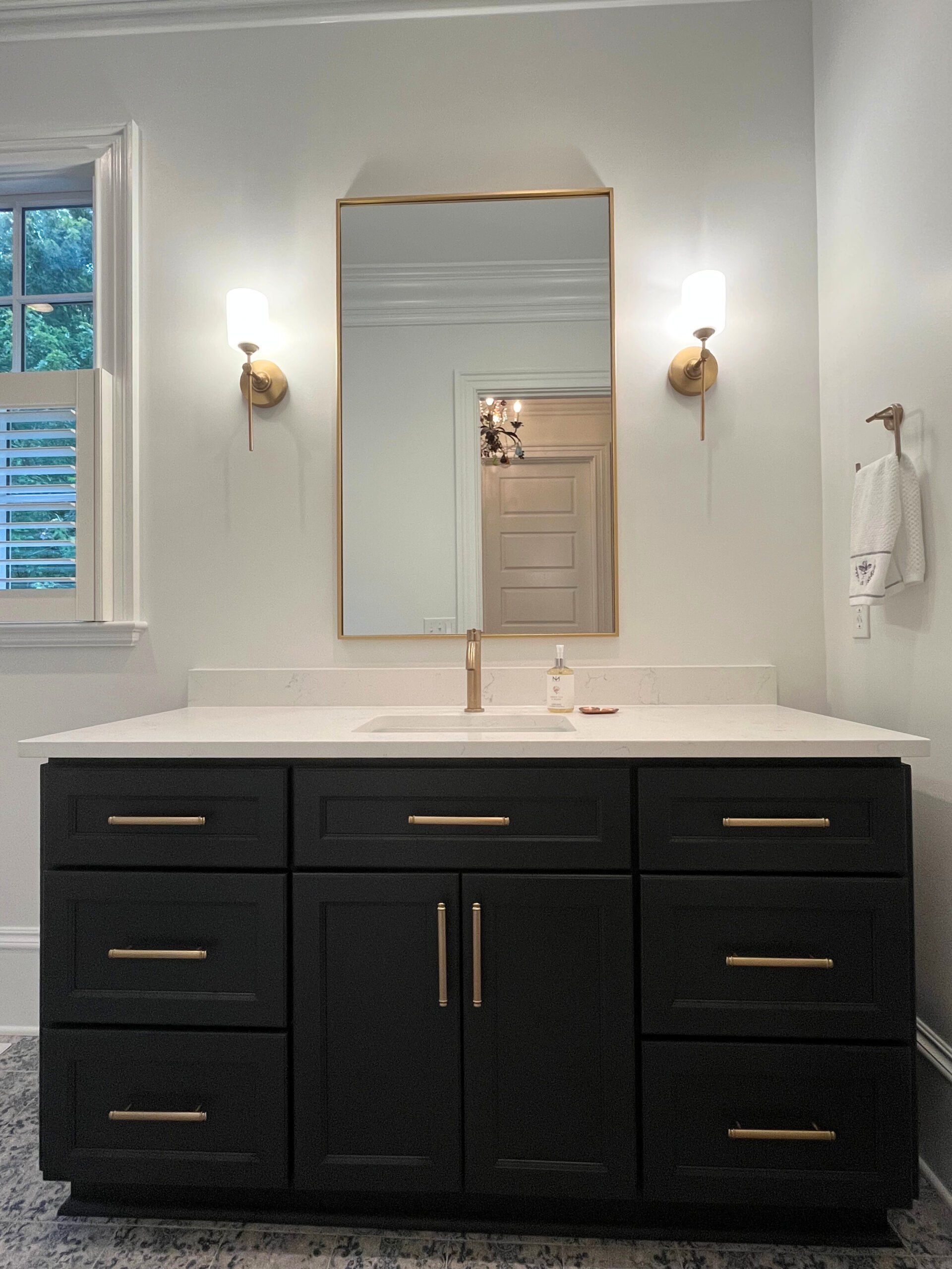 A bathroom with a vanity , sink and mirror.