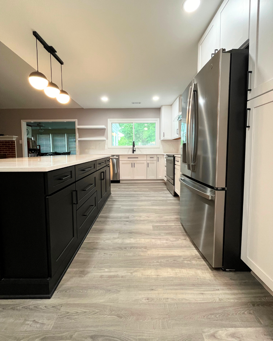 A kitchen with stainless steel appliances and black cabinets