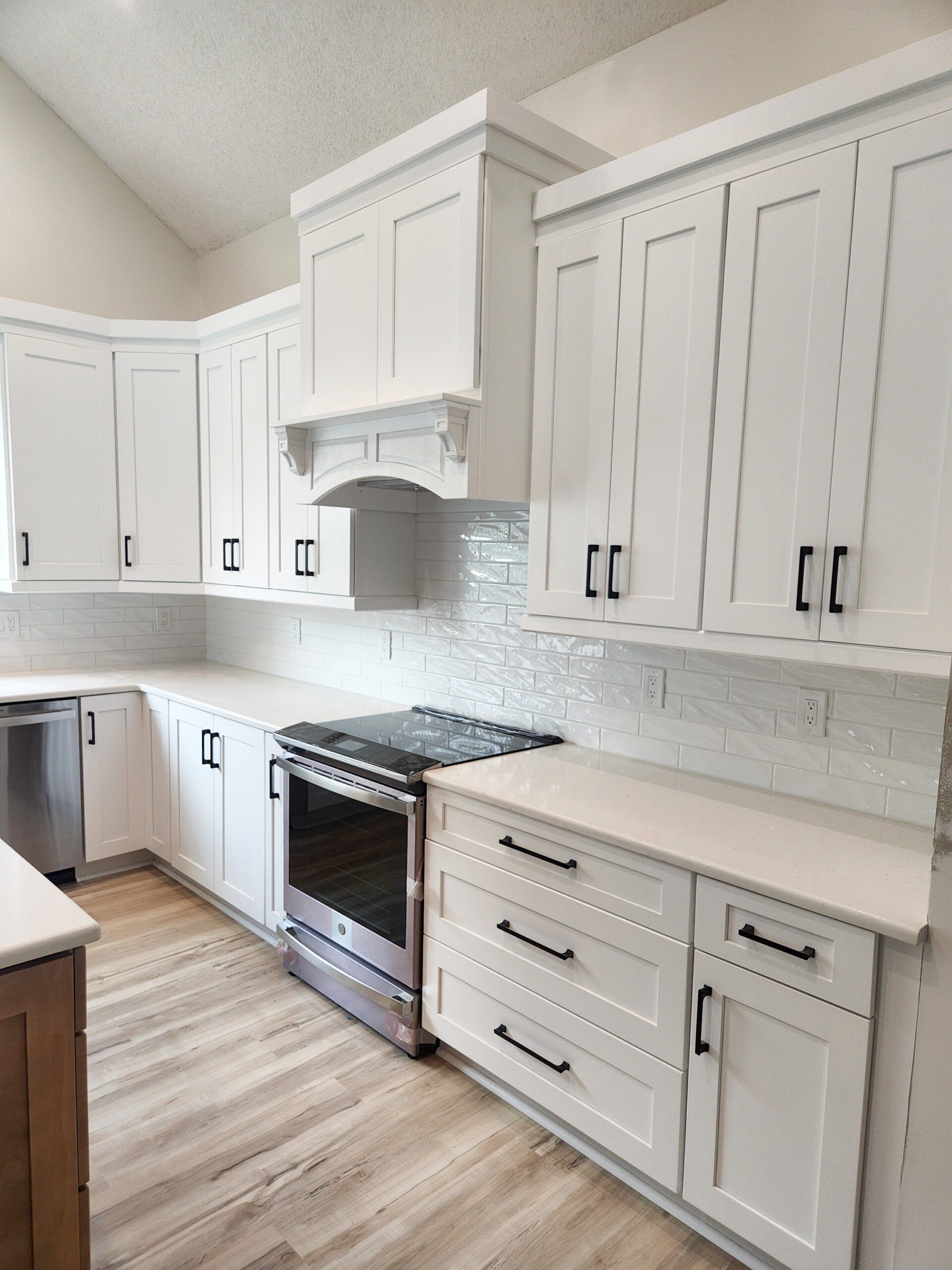 A kitchen with white cabinets and stainless steel appliances