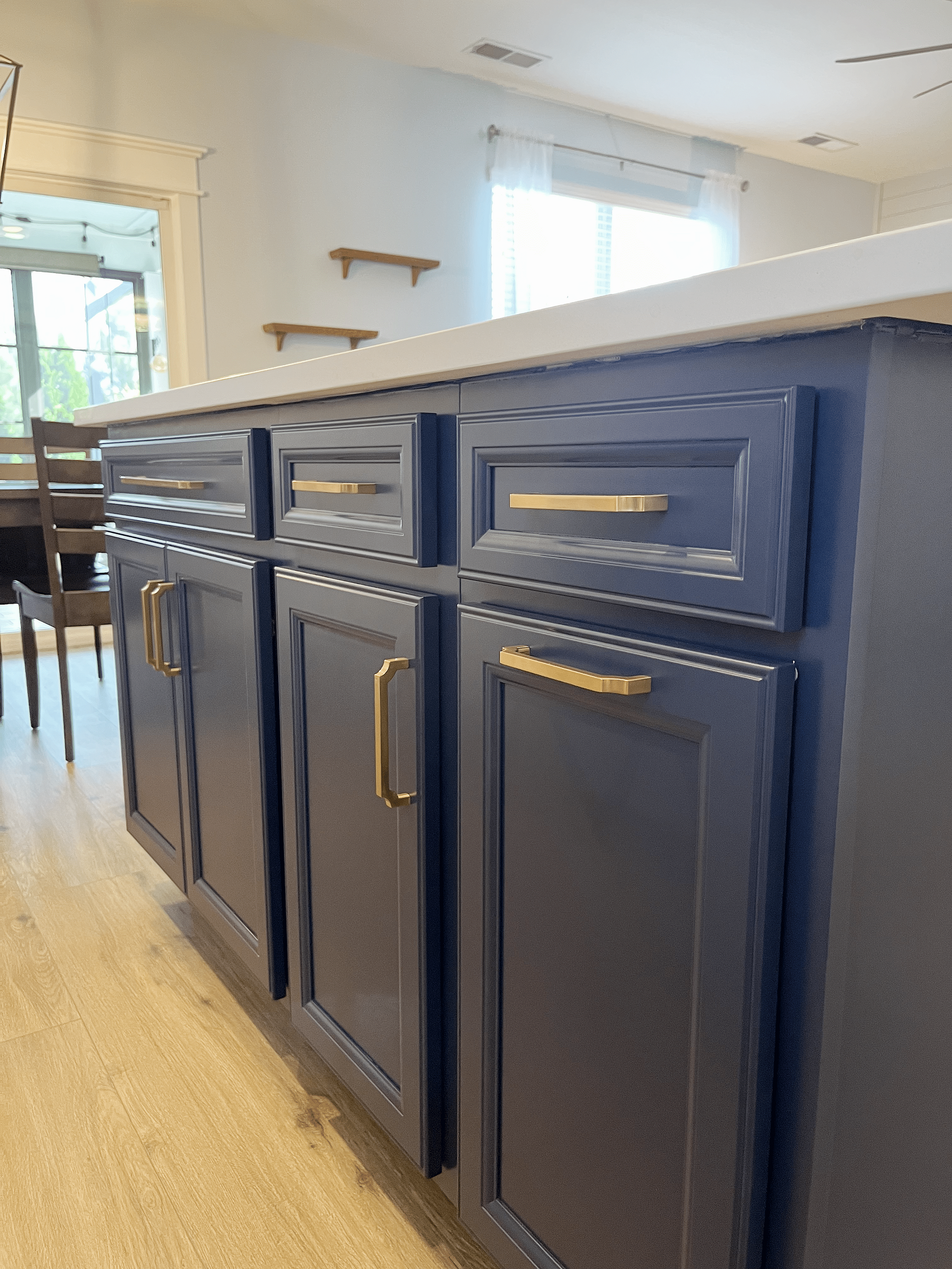 A kitchen with blue cabinets and gold handles.