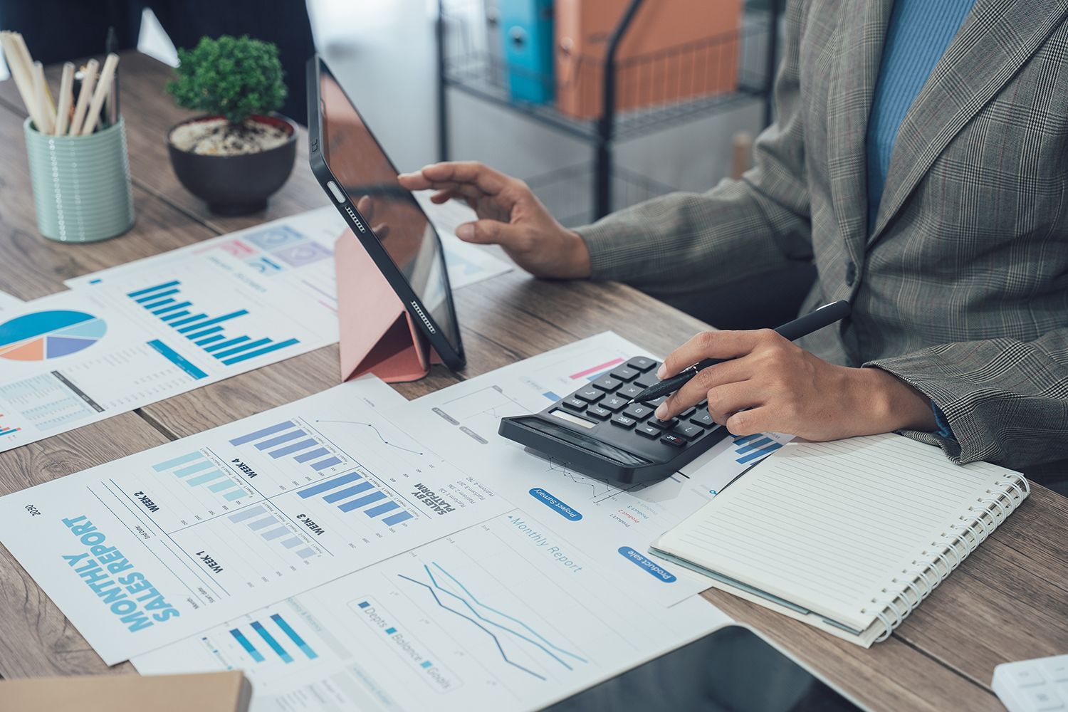 An accountant analyzing tax documents, charts, and a calculator on a clean desk.
