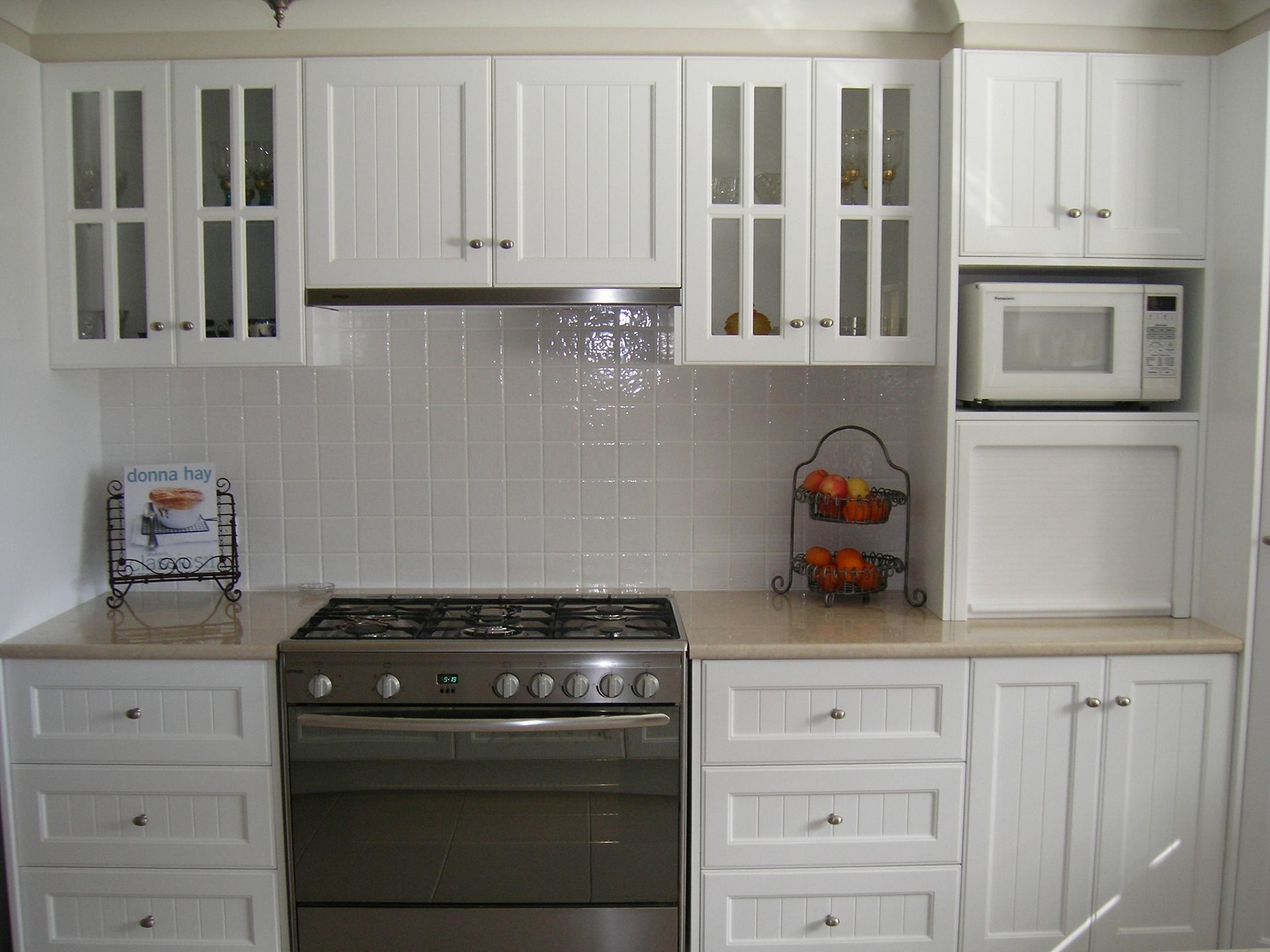 Bright Modern Kitchen with White Cabinets, Gray Island, Stainless Fridge, and Wood Floor — Simmonds Kitchens in Tamworth, NSW