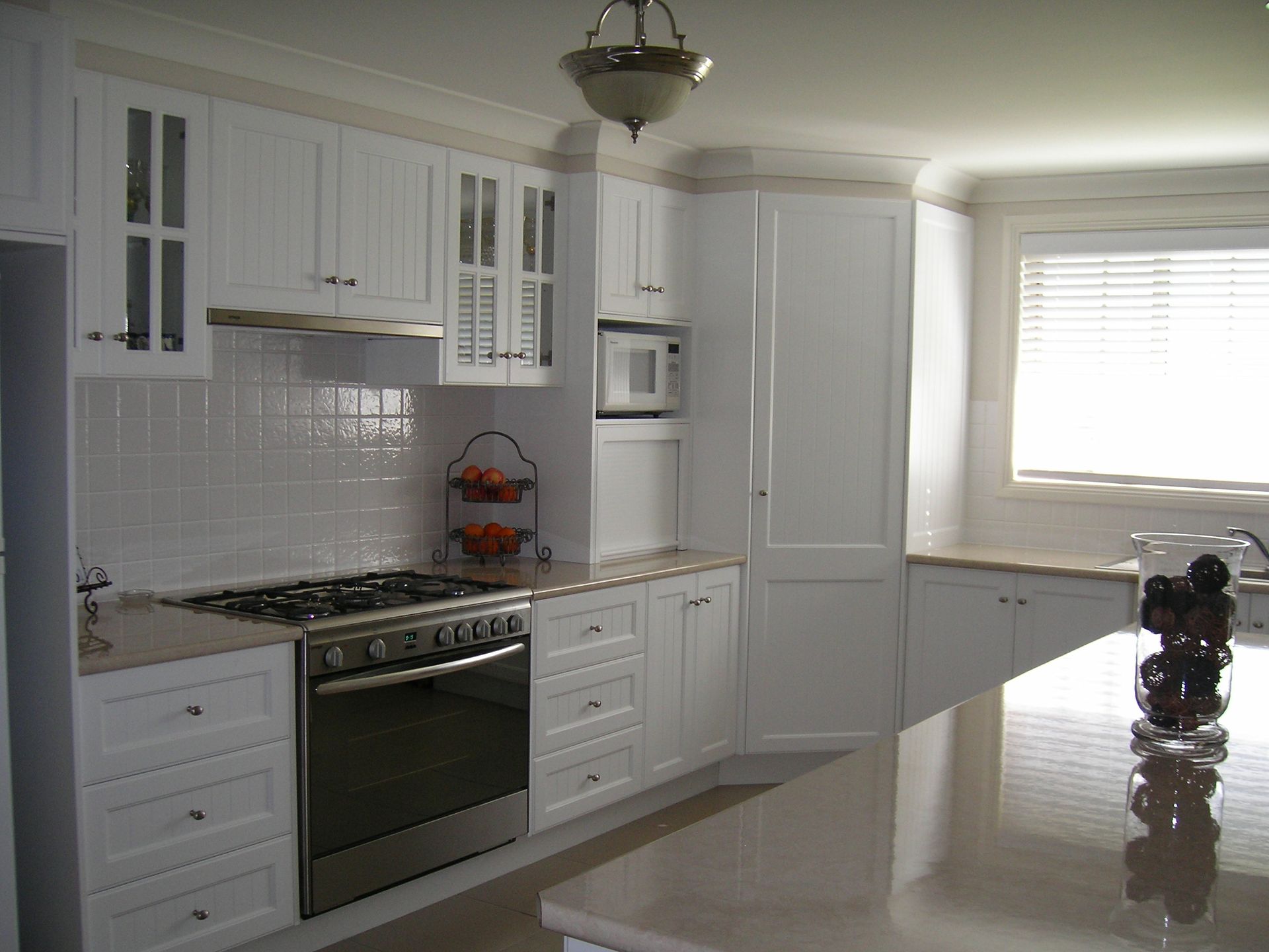Bright White Kitchen with Stainless Stove, White Cabinets — Simmonds Kitchens in Gunnedah, NSW