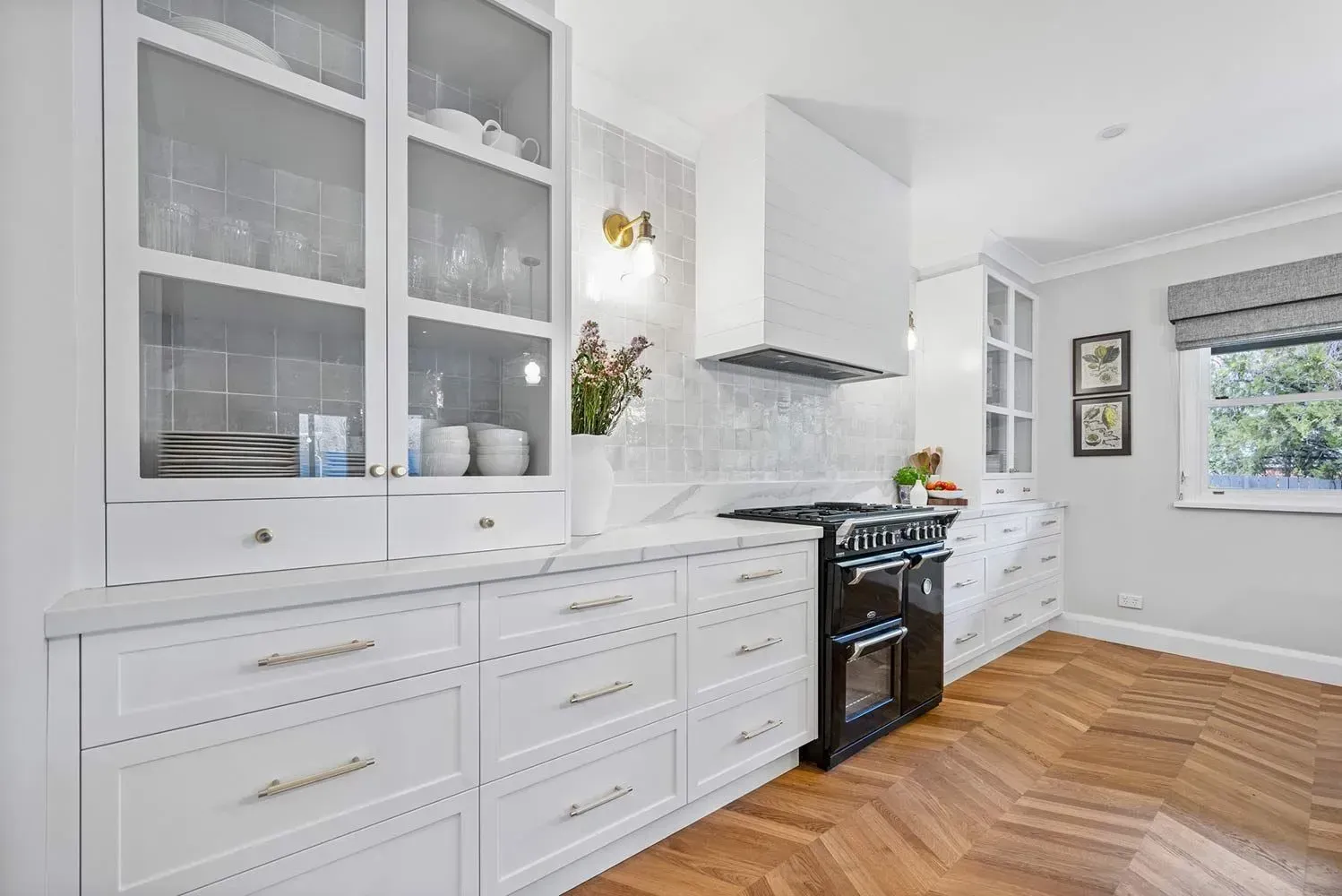 Bright White Kitchen with Glass-Front Cabinets, Black Stove, and Herringbone Wood Floor — Simmonds Kitchens in Narrabri, NSW