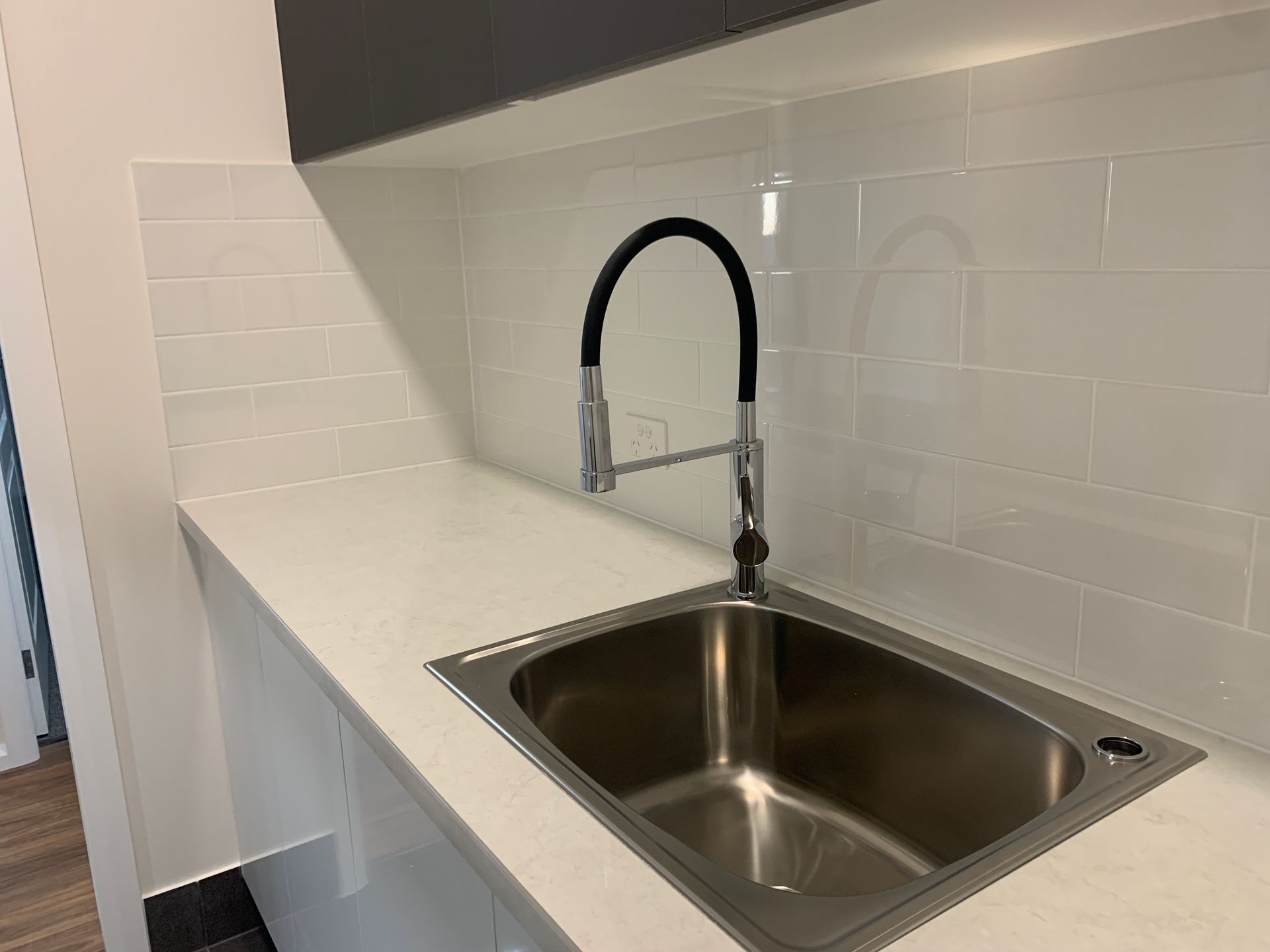 Modern White Kitchen Counter with Stainless Steel Sink and Black Gooseneck Faucet — Simmonds Kitchens in Narrabri, NSW