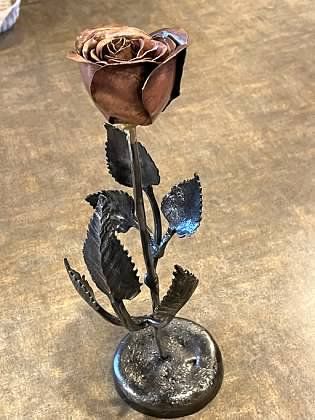 A wrought iron rose is sitting on a table.