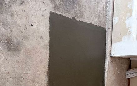 electrician at work. boring hole for electric outlet by power tool drill.