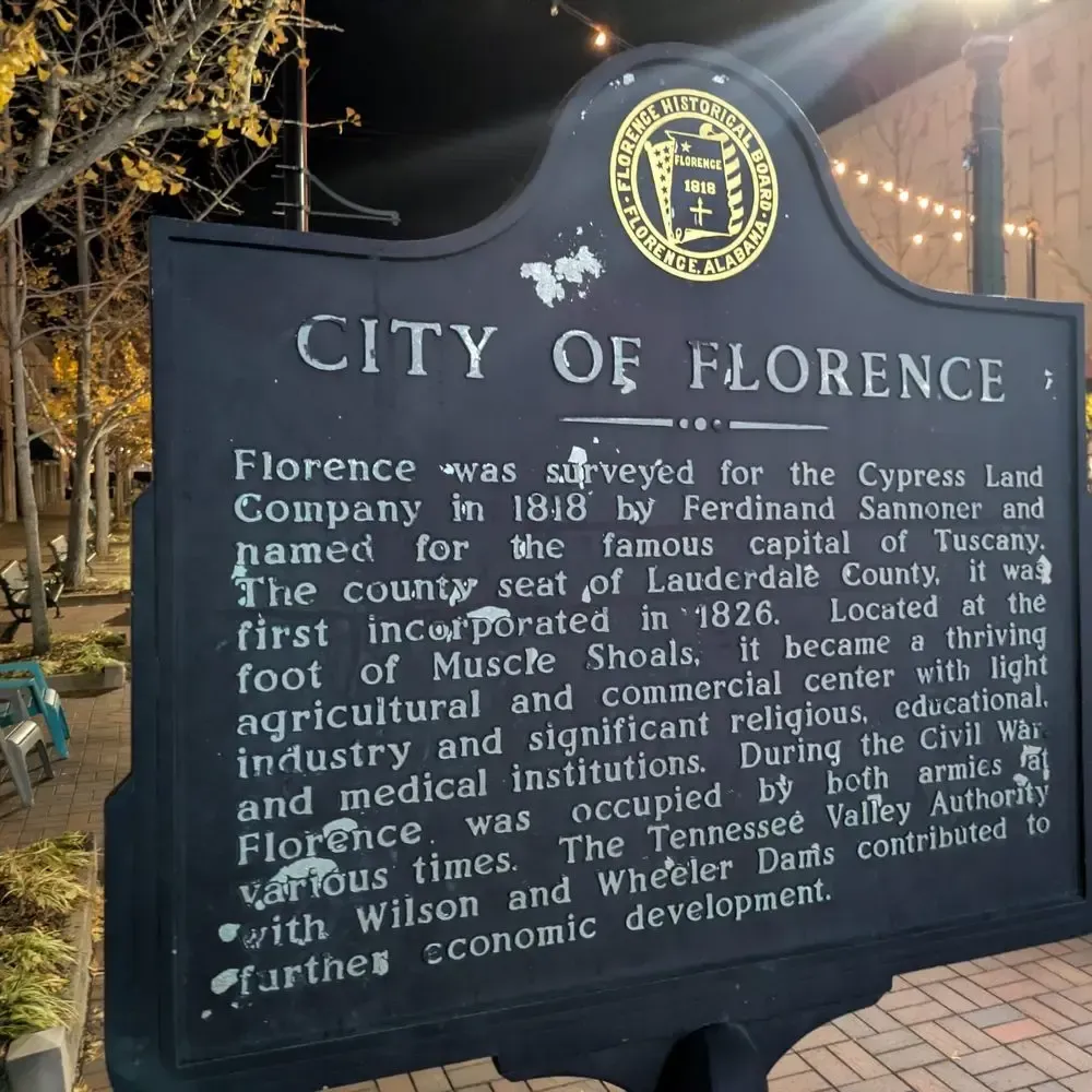 A black metal historical marker titled 