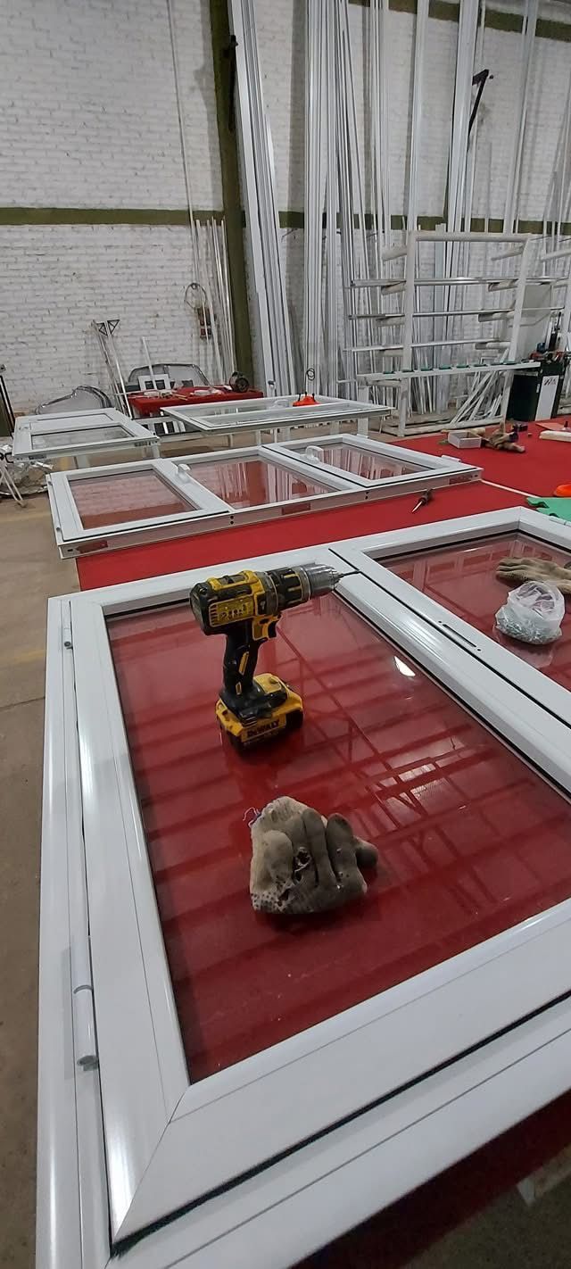 Pequeño robot amarillo sobre una plataforma roja en un área de pruebas industriales, con cableado y estructuras al fondo.