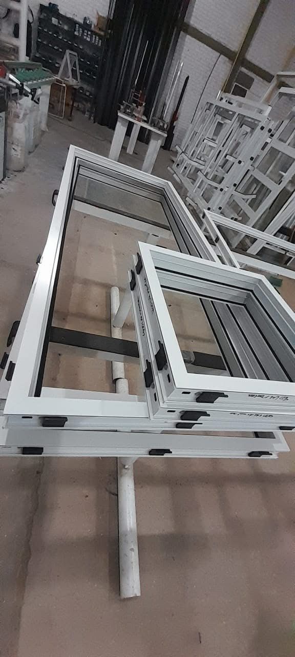 Stacked white metal frames in a warehouse aisle