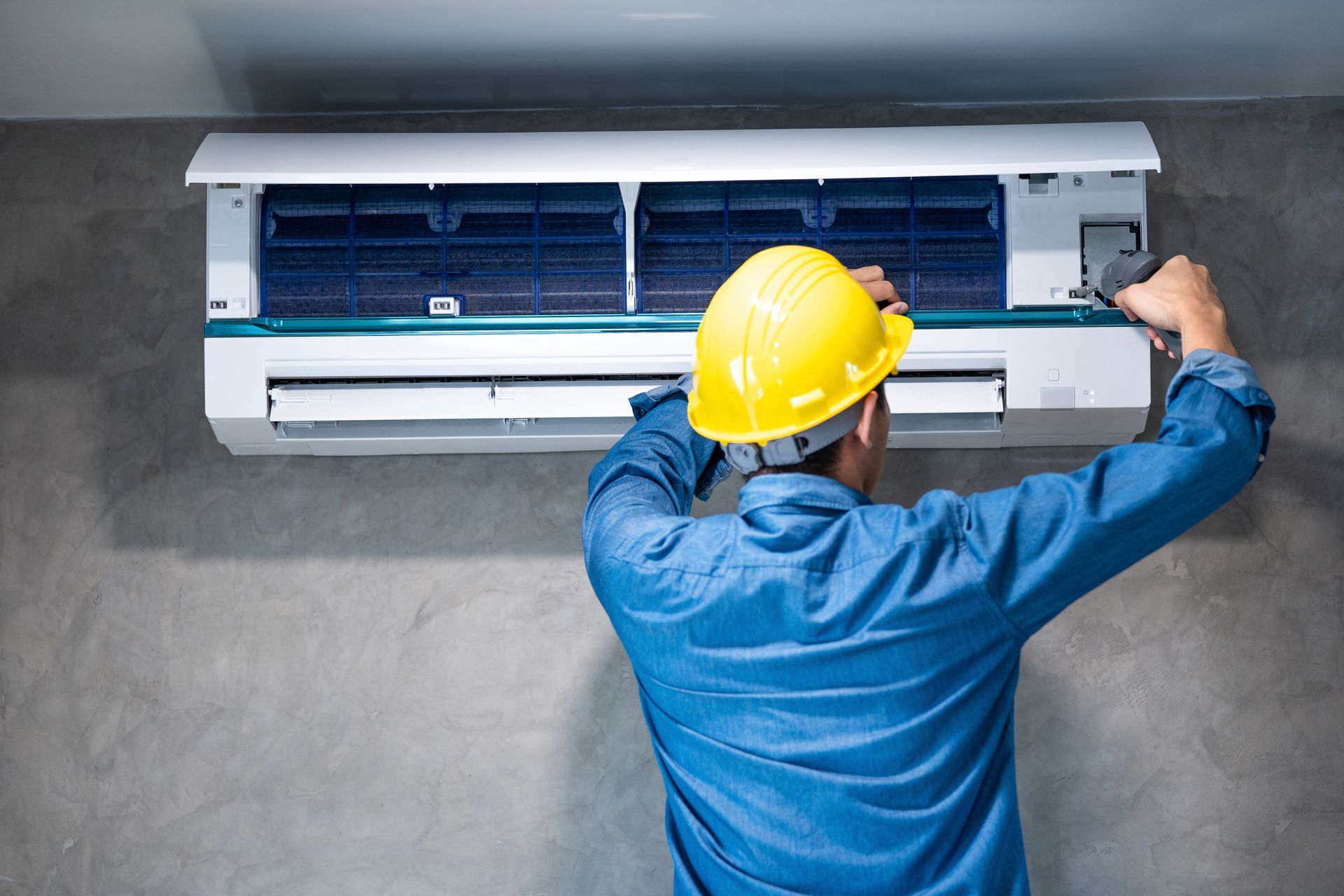 Air conditioning repair technician adjusting unit components to improve performance Air conditioning repair technician adjusting unit components to improve performance