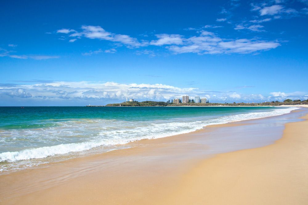 A Beach With A City In The Background On A Sunny Day — Climatech In Caloundra, QLD