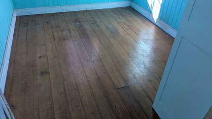 Empty Room With Worn Wooden Floorboards and Light Blue Walls — The Good Wood Polished Timber Floors in Highfields, QLD