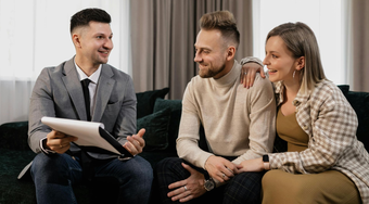 Salesman talking to a couple about buyinh a house