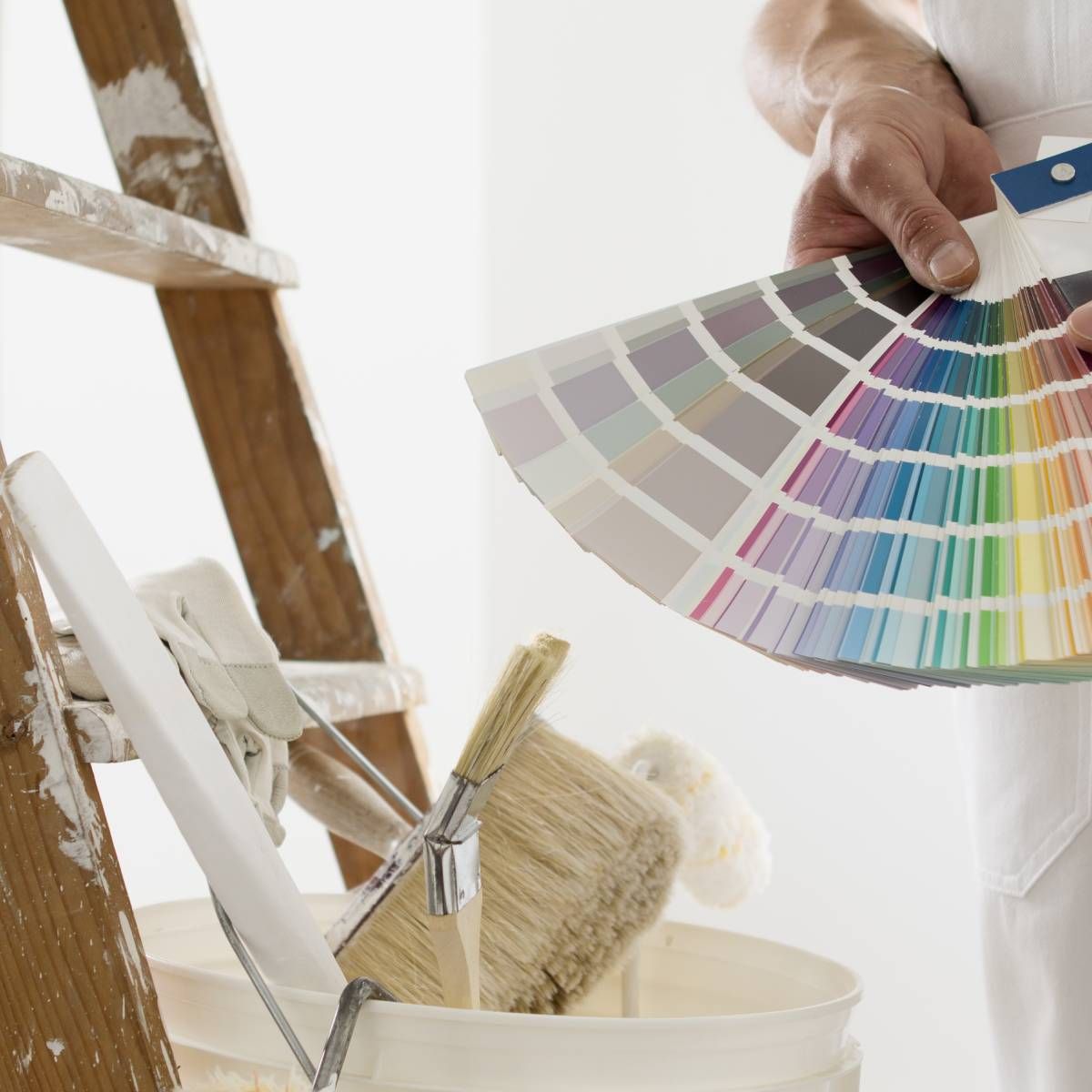 A person is holding a color palette in front of a ladder