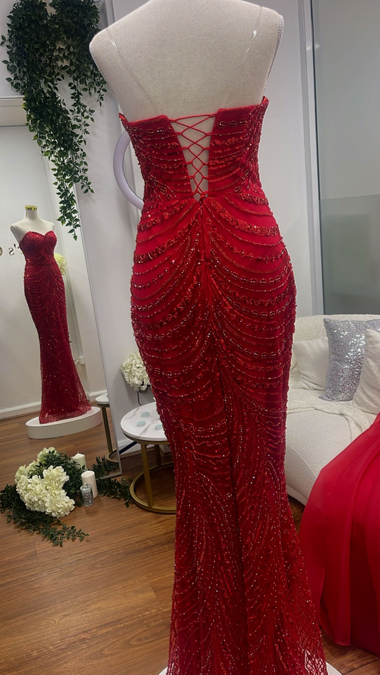 Red Beaded Strapless Mermaid Gown on a Dress Form in a Showroom โ Nur's Collection In Rockdale, NSW