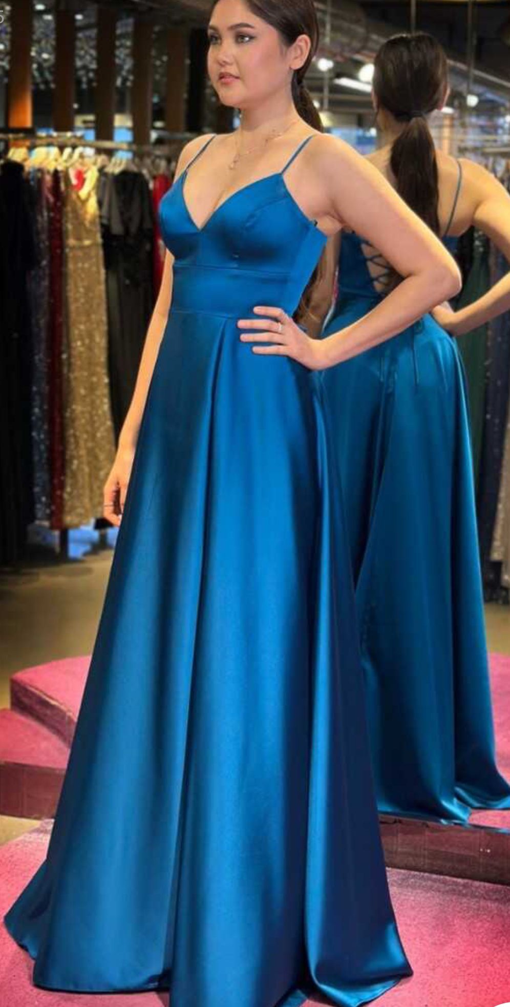 Woman in a Bright Blue Satin Gown Standing on a Pink Carpet, Posing in Front of a Mirror — Nur's Collection In Rockdale, NSW