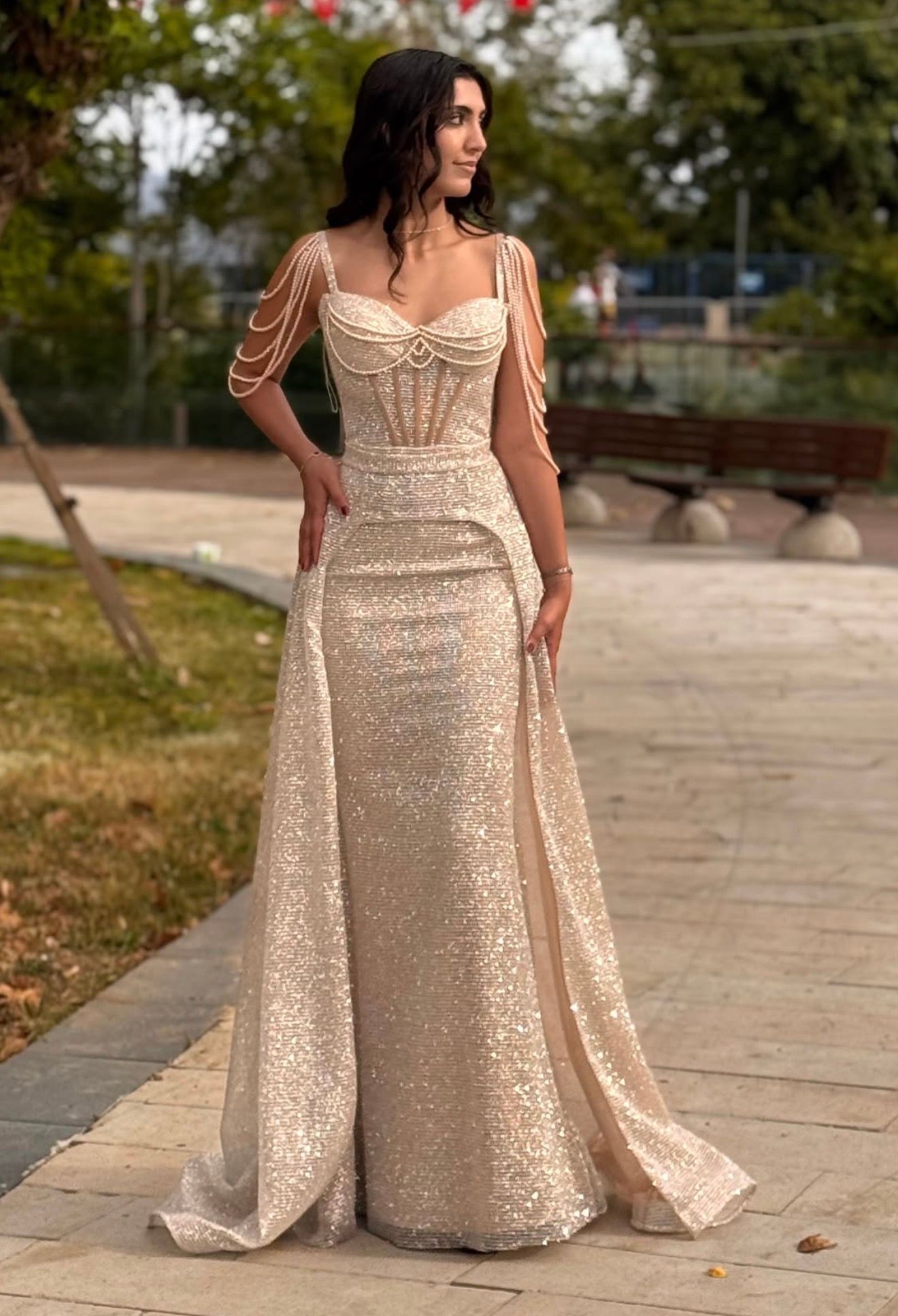 Woman in a Sparkling Champagne Gown Posing Outdoors on a Walkway — Nur's Collection In Rockdale, NSW