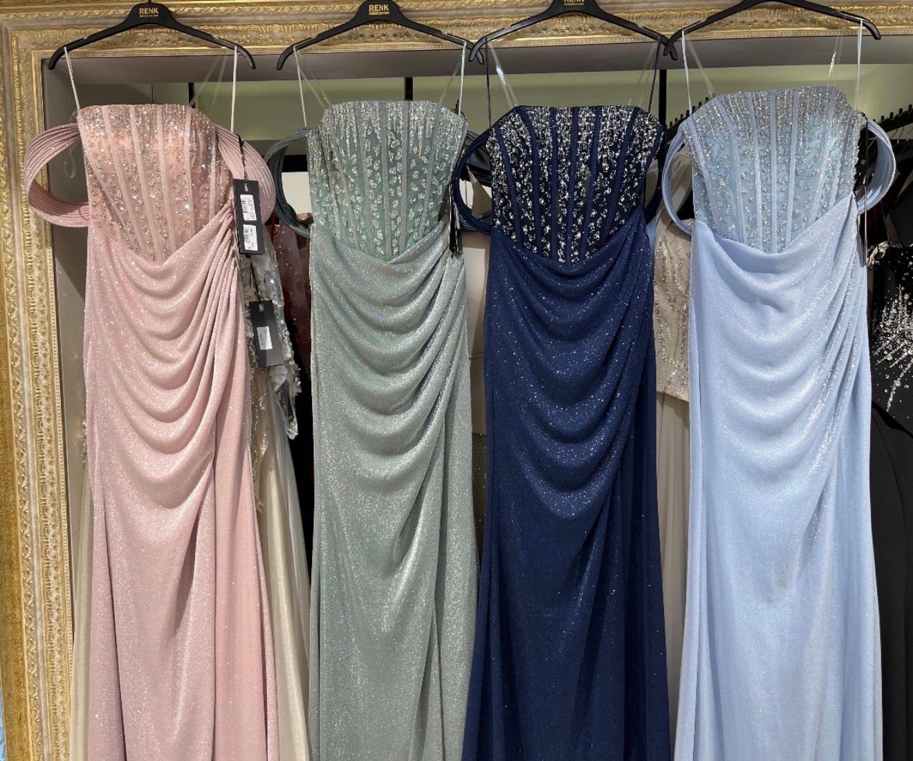 Four Beaded Formal Dresses in Pink, Green, Navy, and Light Blue Hanging on a Rack — Nur's Collection In Rockdale, NSW