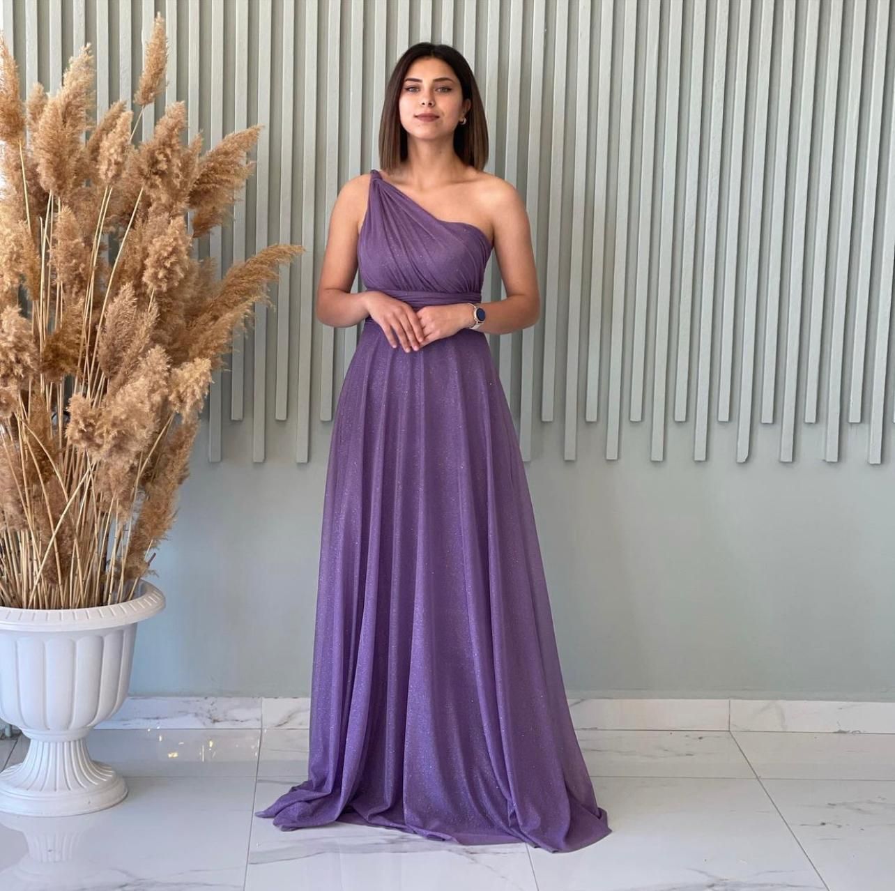 Woman in a Purple One-shoulder Gown Standing Against a Textured Wall โ Nur's Collection In Rockdale, NSW