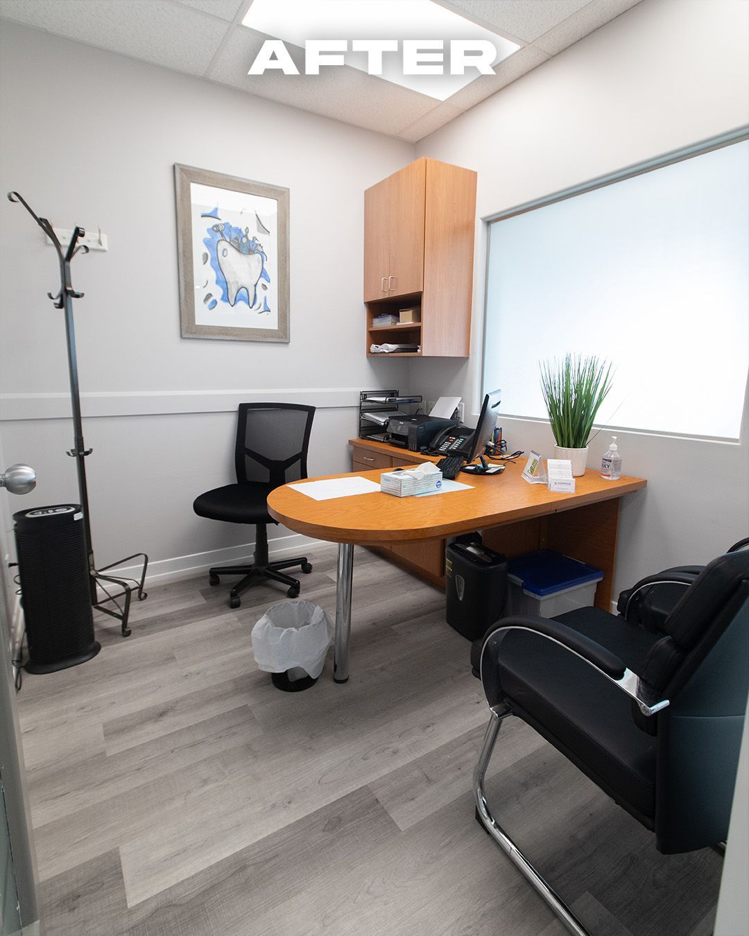 Office space with gray walls, wood desk, black chairs, and light gray flooring.