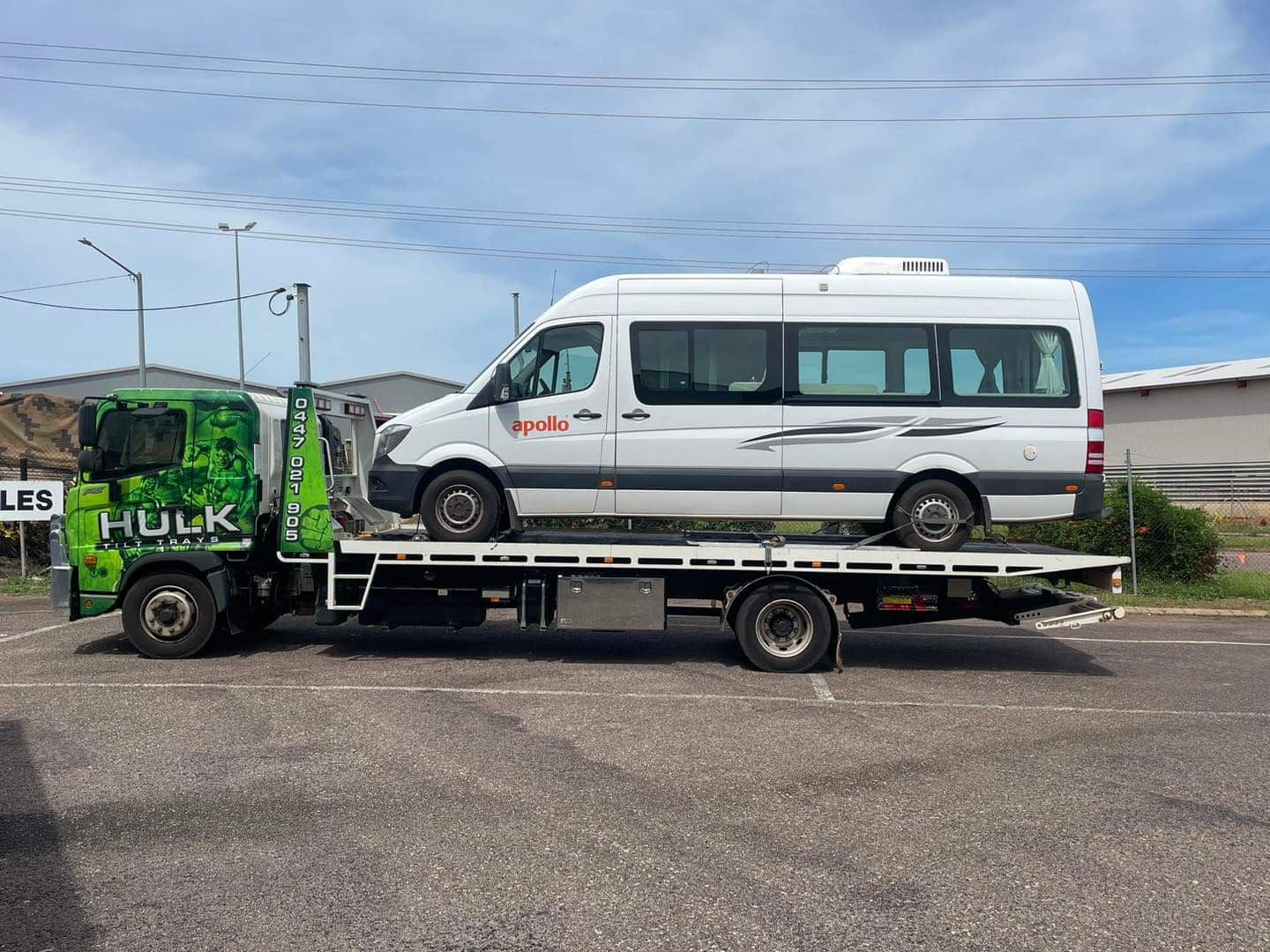 A Tow Truck Is Towing a White Van in A Parking Lot — Hulk Tilt Trays In Humpty Doo, NT