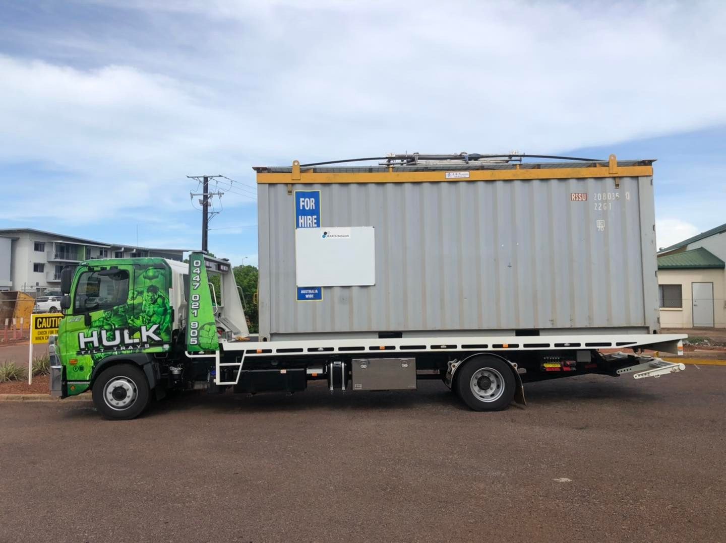 A Tow Truck with A Container on The Back Is Parked on The Side of The Road — Hulk Tilt Trays In Humpty Doo, NT