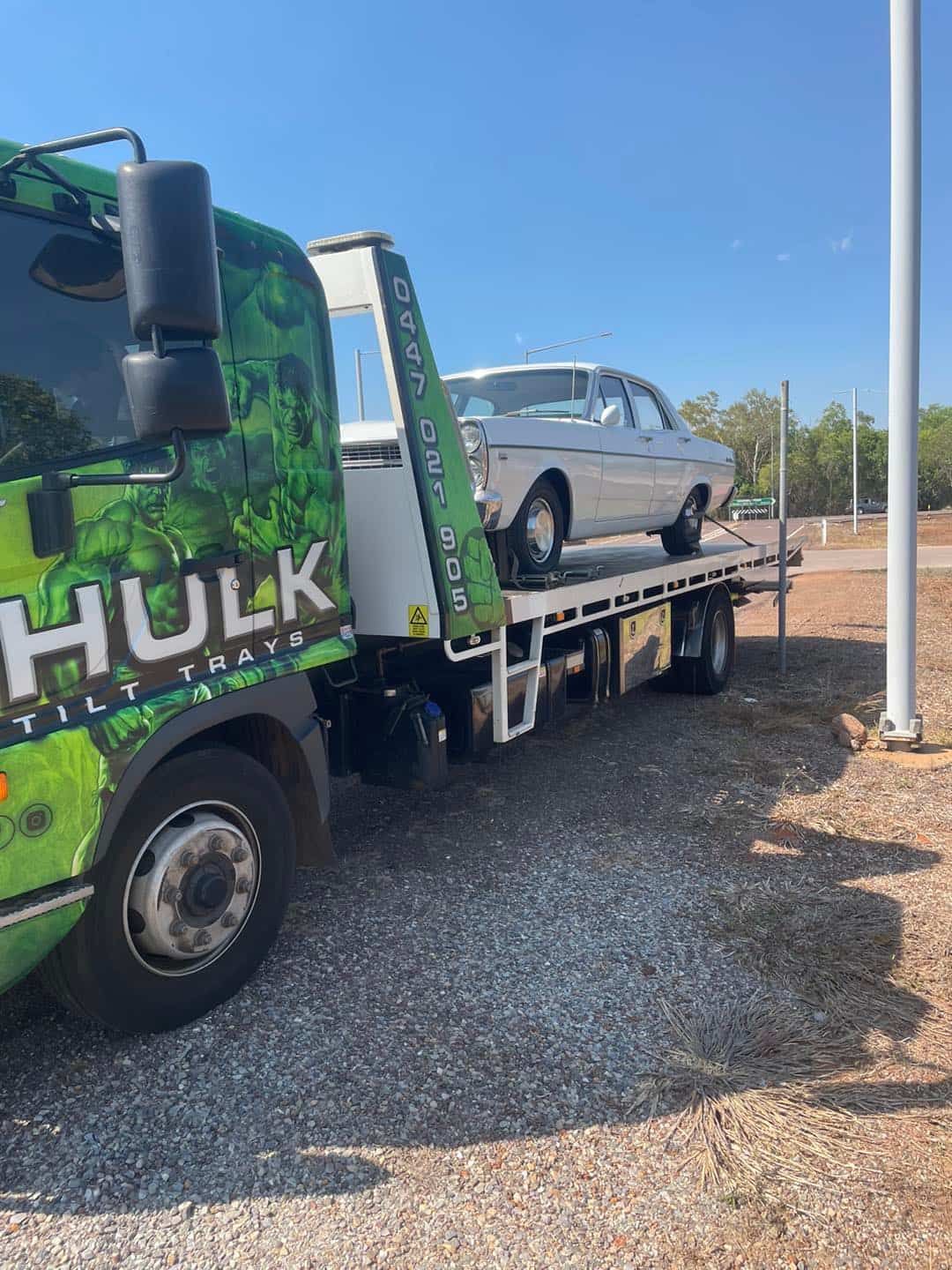 A Tow Truck with A Car on The Back Is Parked in A Gravel Lot — Hulk Tilt Trays In Humpty Doo, NT