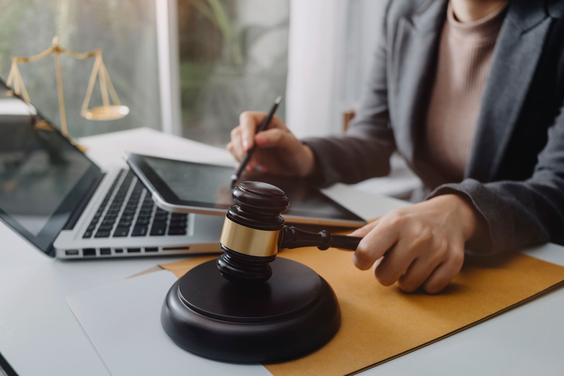 Lawyer with gavel and pen at desk beside laptop, in a legal office Lawyer with gavel and pen at desk beside laptop, in a legal office