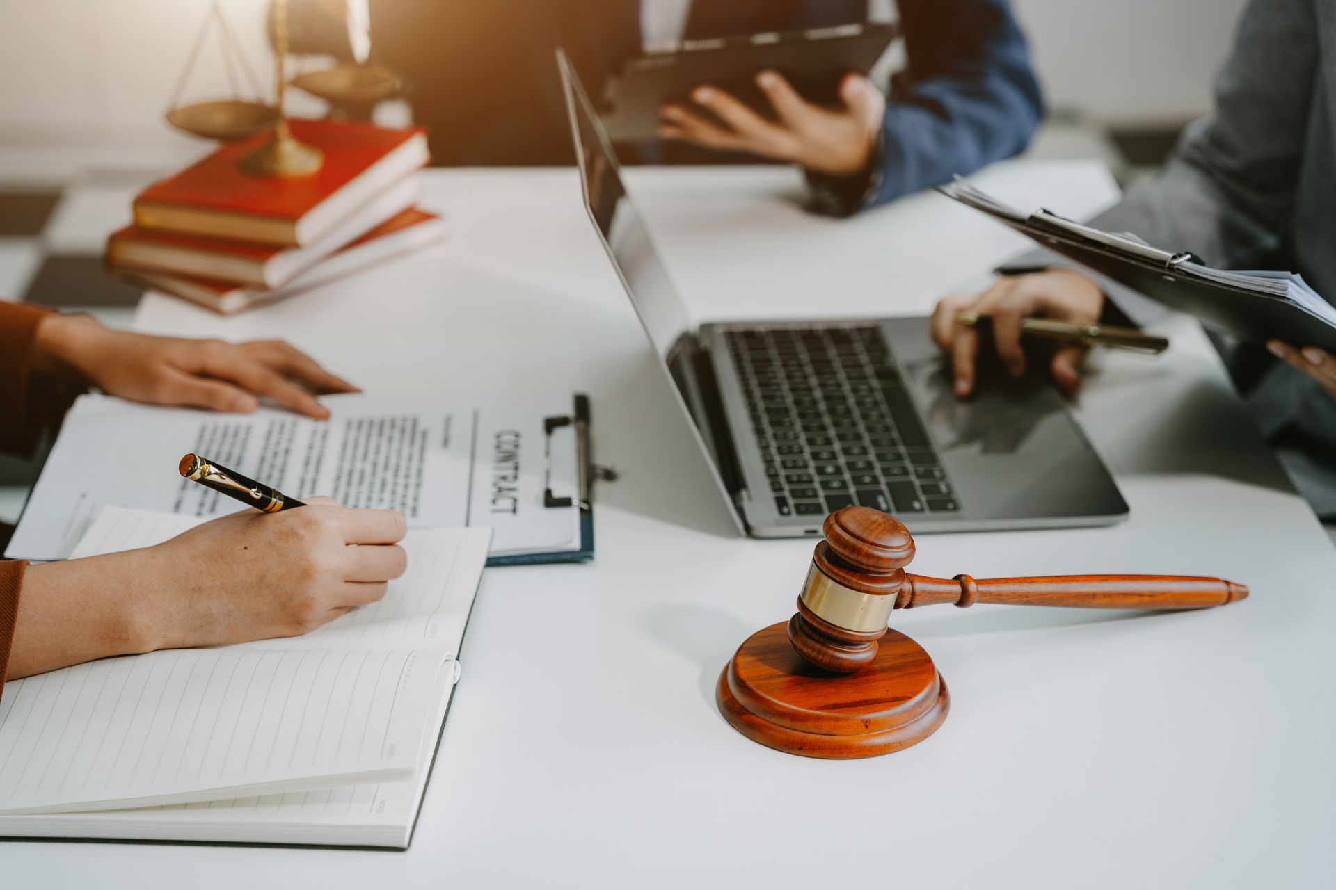 Lawyers reviewing documents at a table with a gavel and laptop in a meeting room Lawyers reviewing documents at a table with a gavel and laptop in a meeting room