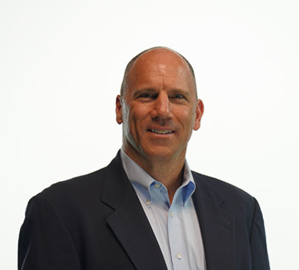 Wade Hoffman, founder of Blueprint Security in a suit and blue shirt is smiling for the camera